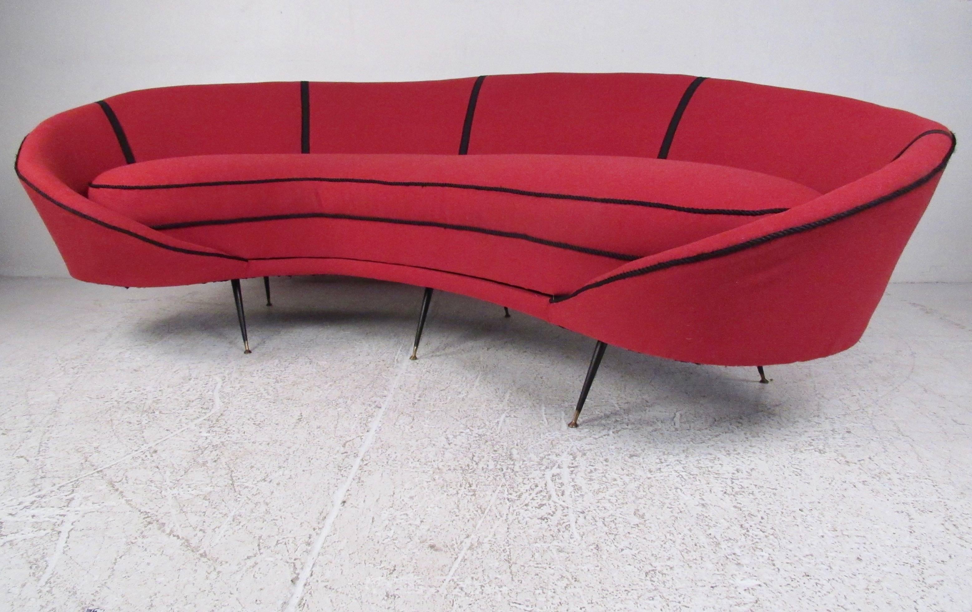 This stunning Italian modern sofa features vibrant red upholstery, braided trim, and tapered legs. After the Mid-Century Modern style of Ico Parisi this large sofa makes an impressive statement in home, hotel, or business seating area. Please