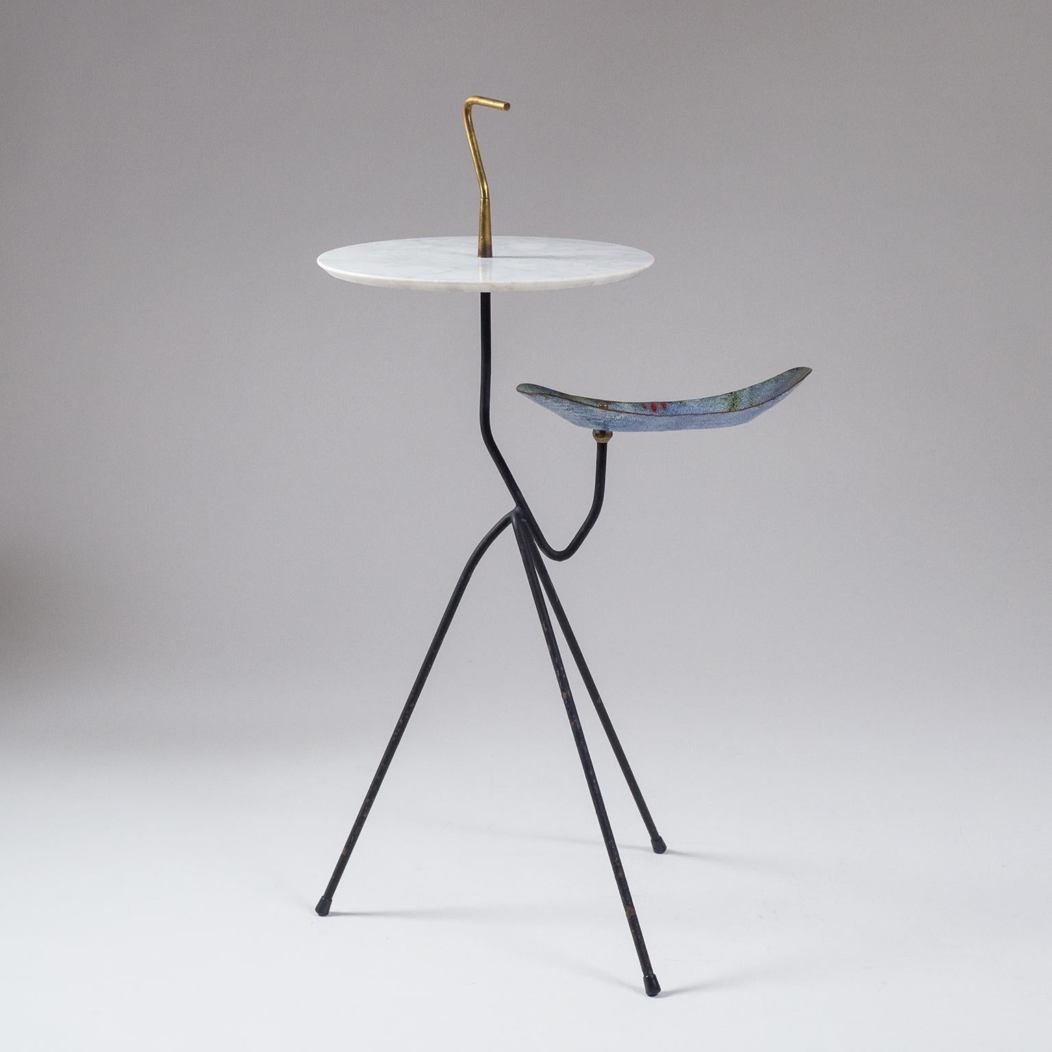 Exceptional Italian midcentury smokers table or side table with integrated catch-all. A very sculptural design with an organically shaped steel tripod base, a round white marble tabletop and brass grip finial. Underneath the marble top is an