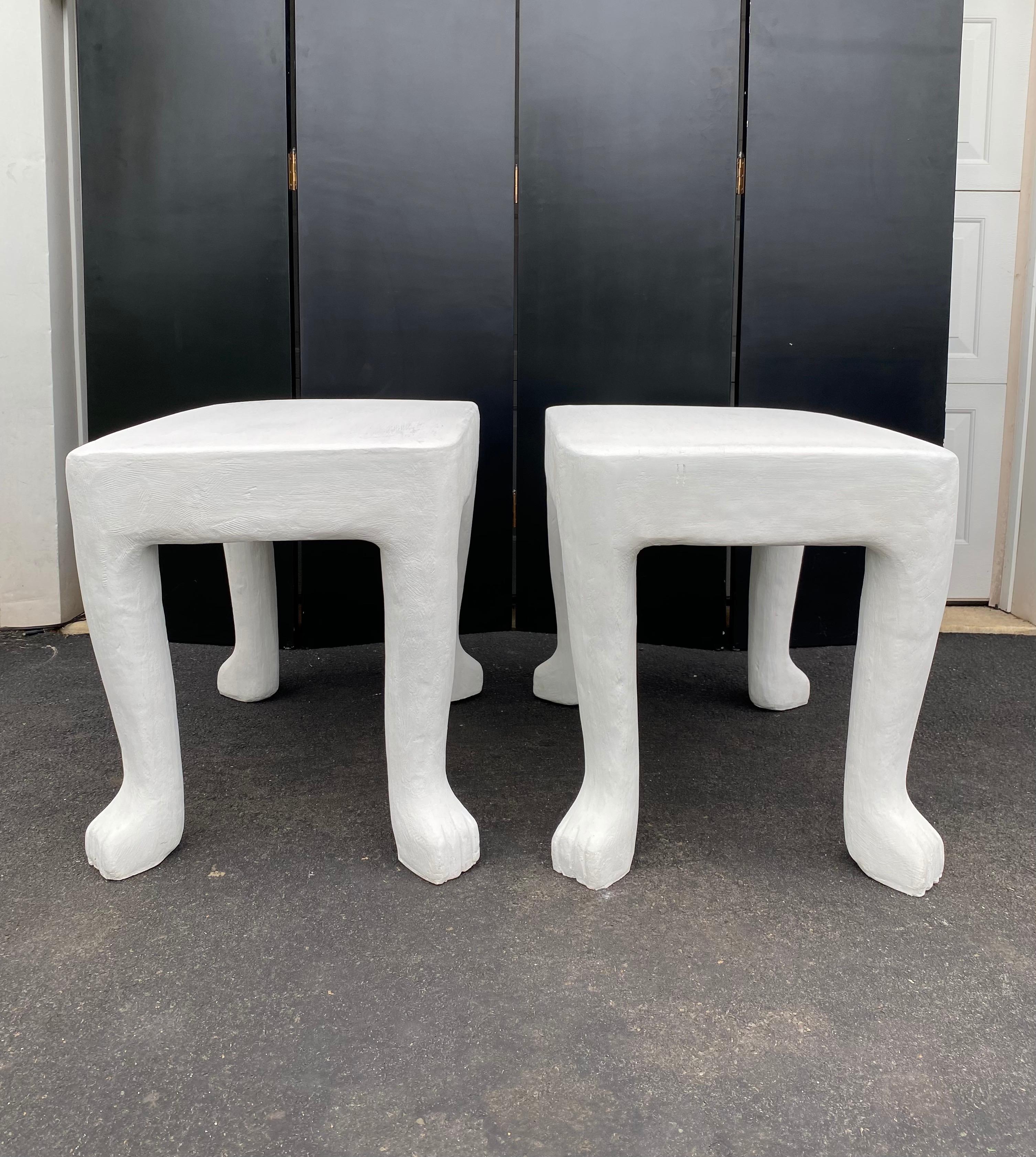 Pair of iconic John Dickinson footed end side tables. These early 2000s sculptural anthropomorphic tables are made of glass-fiber reinforced concrete in original plaster chalk white matte finish. 

These authentic statement pieces are artfully cast