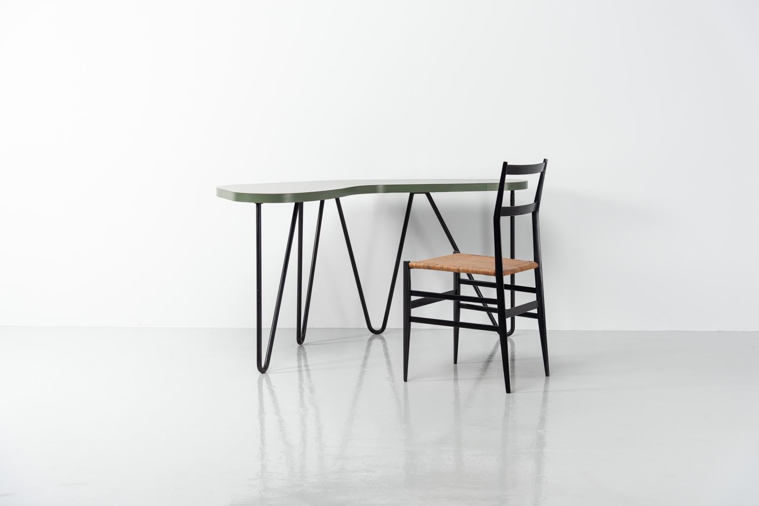 Beautiful kidney shaped writing table by unknown designer in the style of Jean Royere and Jacques Hitier, made in France 1950. The desk is made of a black painted tubular frame and the top is made of green laminated wood. The zigzag tubular metal