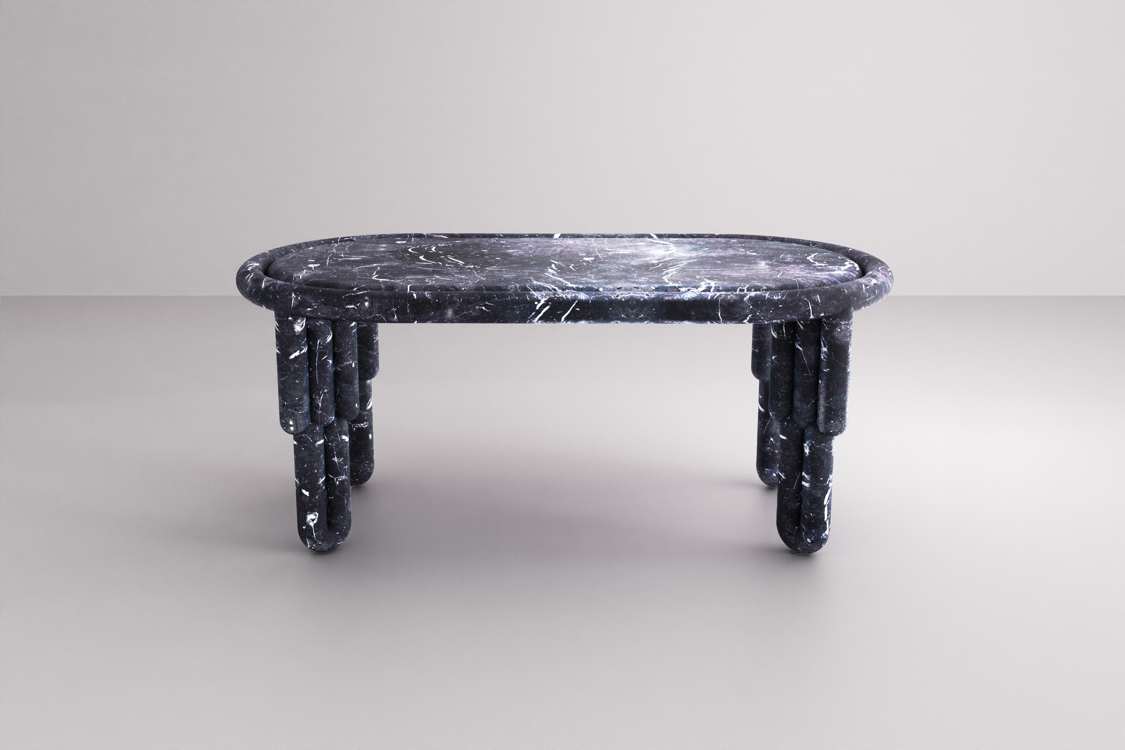 La table de salle à manger Kipferl se caractérise par un plateau oblong enchâssé dans un profil circulaire. Il se caractérise par des pieds sculpturaux composés de trois bâtons qui sont soutenus à la base par des extrémités incurvées de deux bâtons.