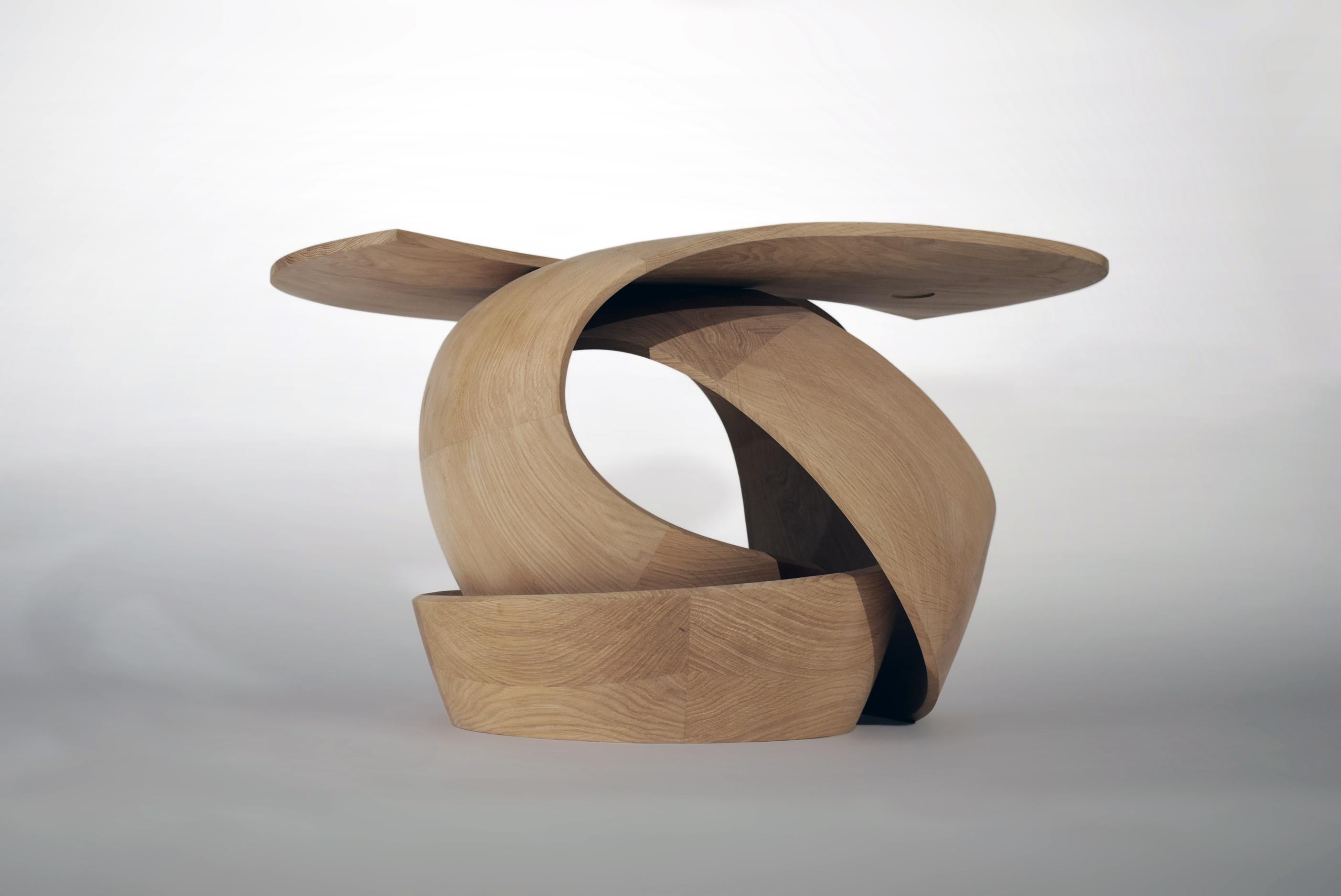 The 'Tula' side table by British designer-maker, Tom Vaughan, is part of a series of work tracing three-dimensional paths of movement through a solid, functional form, in which the artist pushes both material and process to its limit. Made in fumed