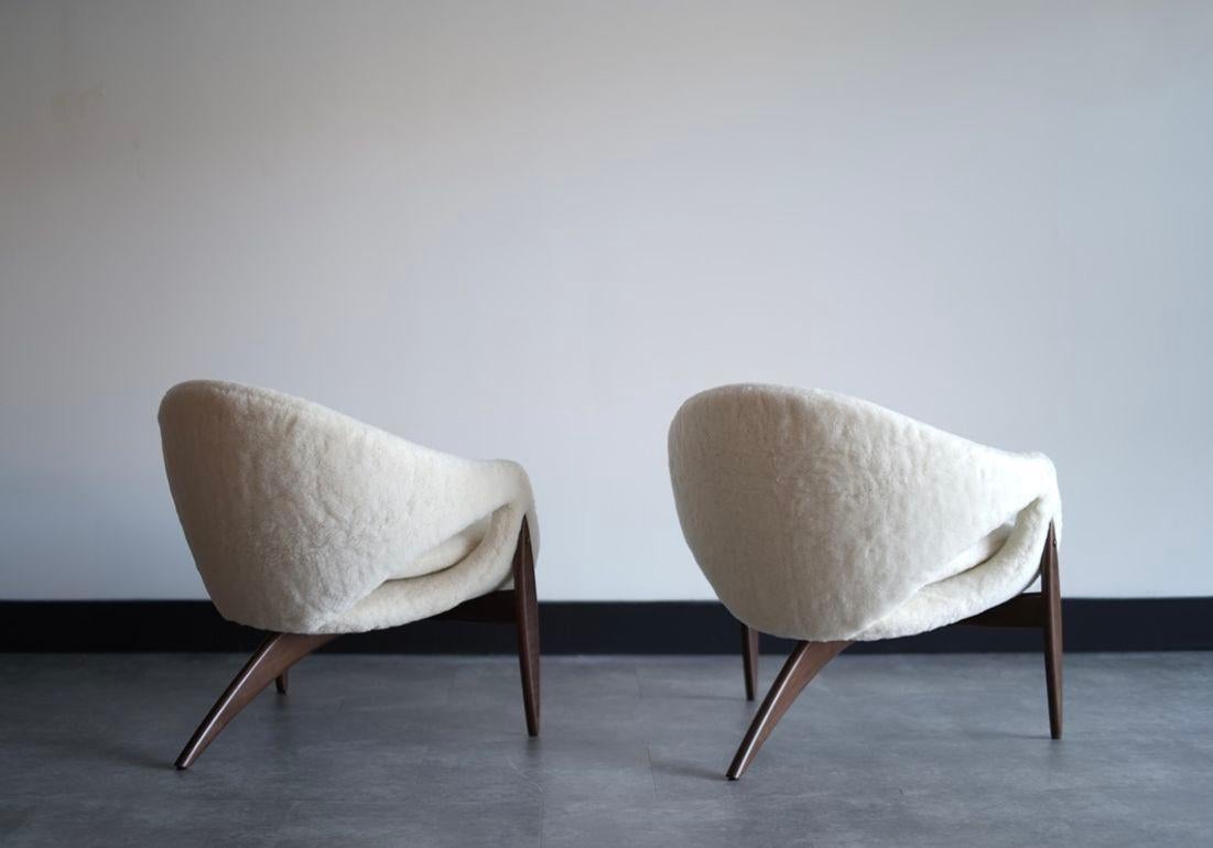 A stunning set of lounge chairs by Luigi Tiengo for Cimon, Montreal, circa 1960s. These iconic pieces feature sculptural walnut frames with an elegant three-leg design, expertly restored to their original splendor. The chairs are reupholstered in