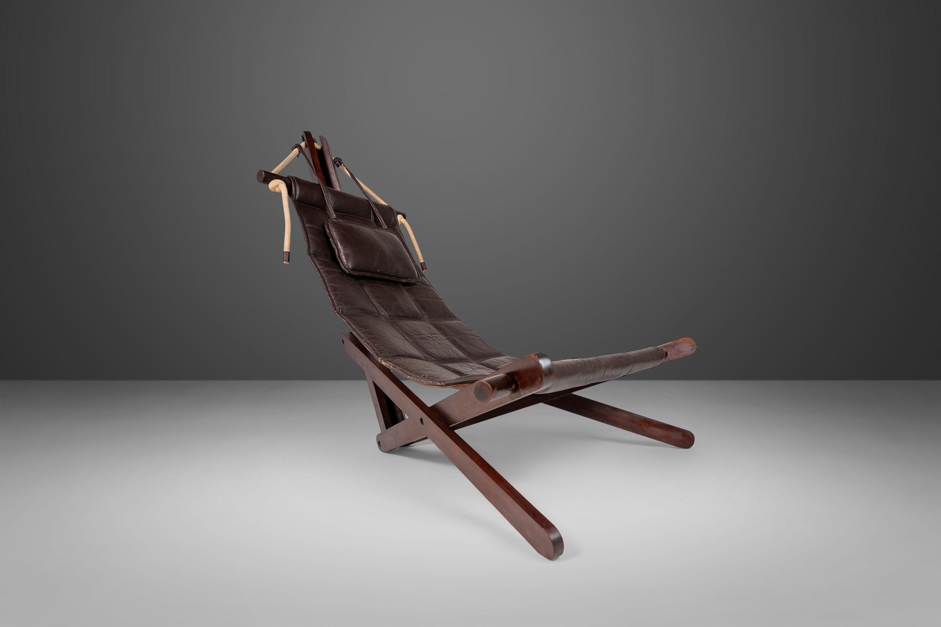 A collectable design by British architect, Dominic Michaelis for Moveis Corazza. The frame of the chair is constructed from Jabota wood (Brazilian Cherry) and supports a patinaed chocolate brown leather sling cushion. Circa