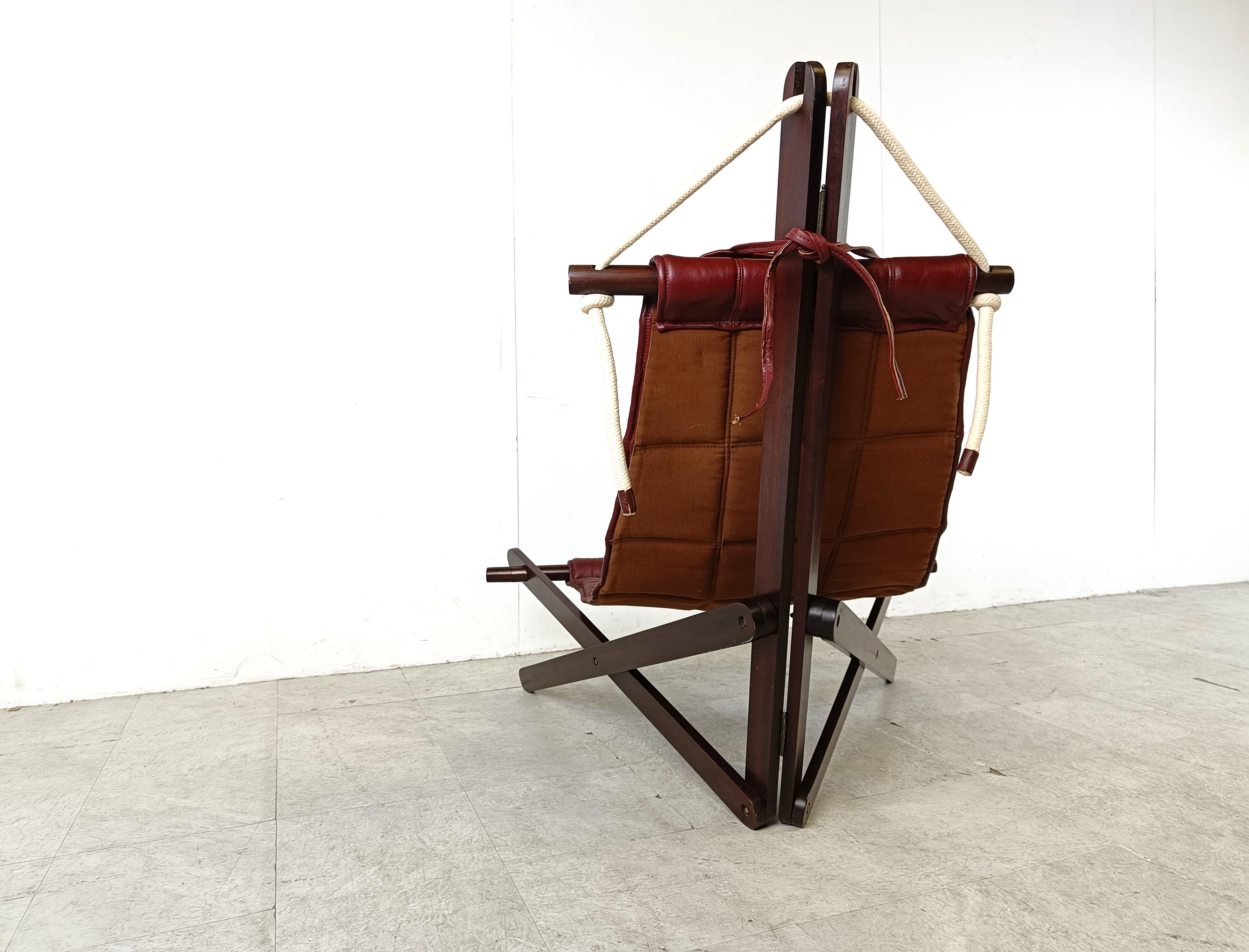 Collectional Lounge Chair, entworfen von Dominic Michaelis für Moveis Corazza, bestehend aus einem skulpturalen Holzrahmen mit einem Sitz aus rotem Leder, der mit Schnüren befestigt ist.

Das maritim inspirierte Design stellt ein Segel mit Rahmen
