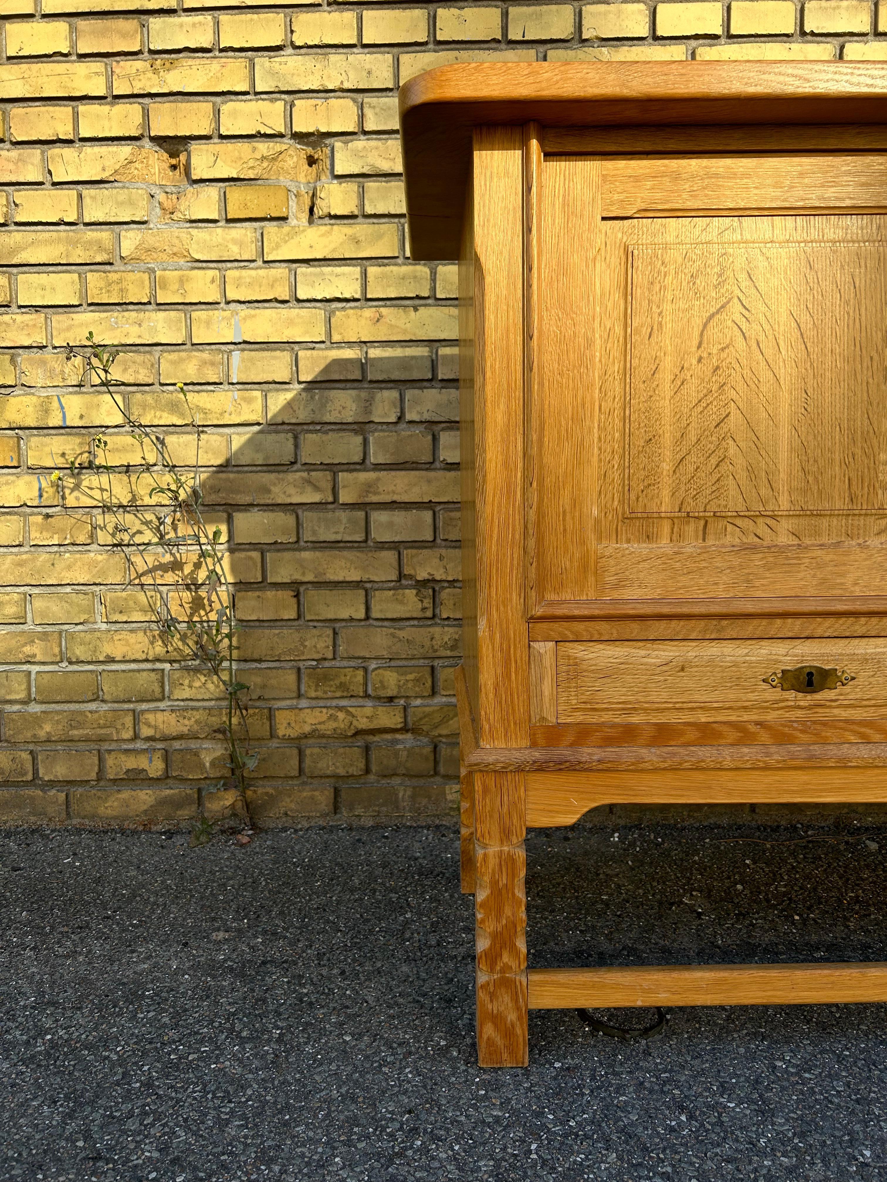Ein skulpturales, niedriges Sideboard aus massiver Eiche des dänischen Designers Henry Kjærnulf aus den 1960er Jahren mit viel Stauraum und schönen dekorativen Türen und Schubladen mit schönen Messing-Details und schönen geschnitzten Beinen.
Das
