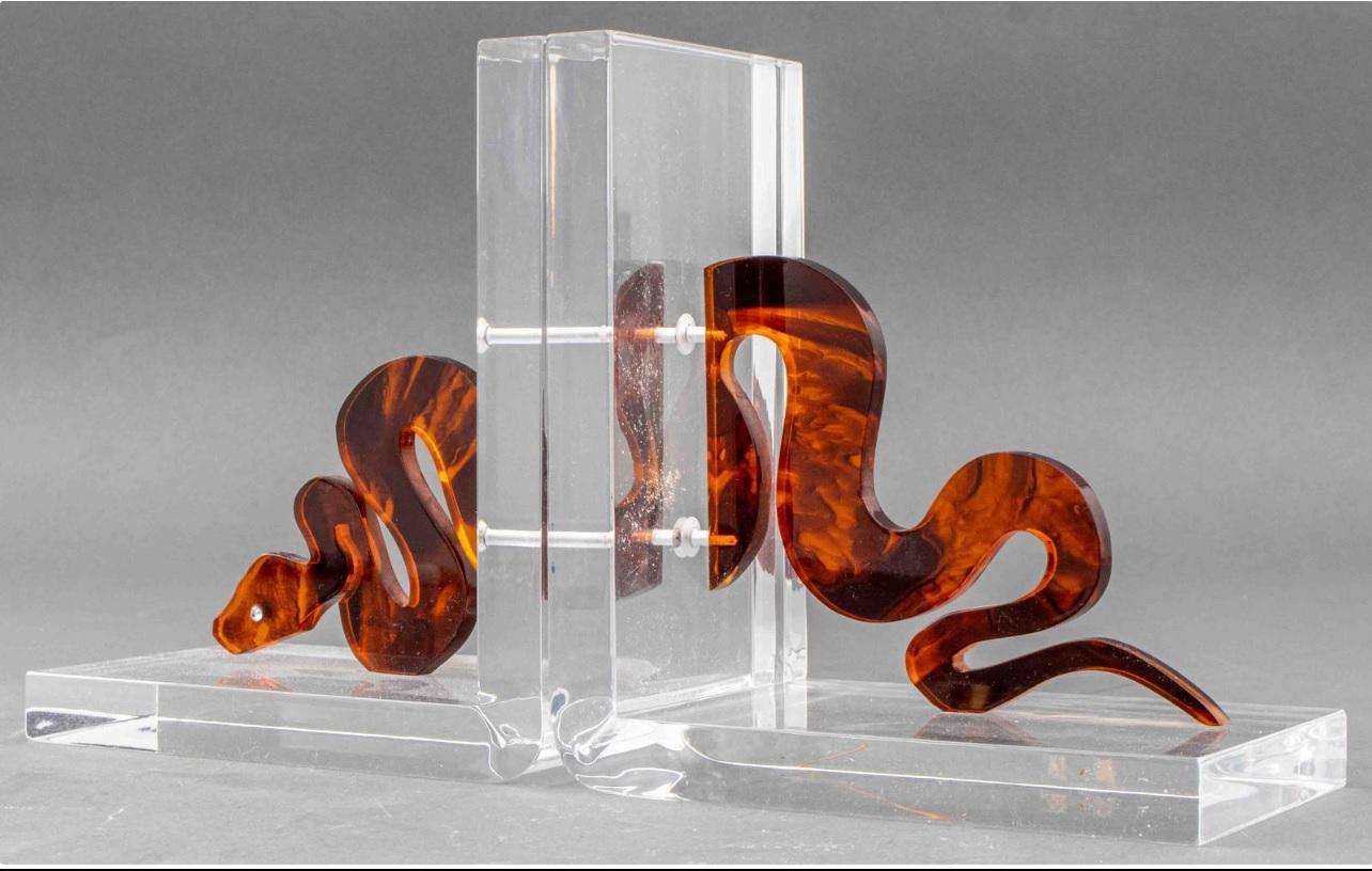 Mesmerizing pair of beautiful lucite bookends by Spisani. Sculpted and graphic, this beautiful piece catapults to sculptural status. The snake rendering is detailed in a tortoise finish that contrasts beautifully with the clear lucite and finished