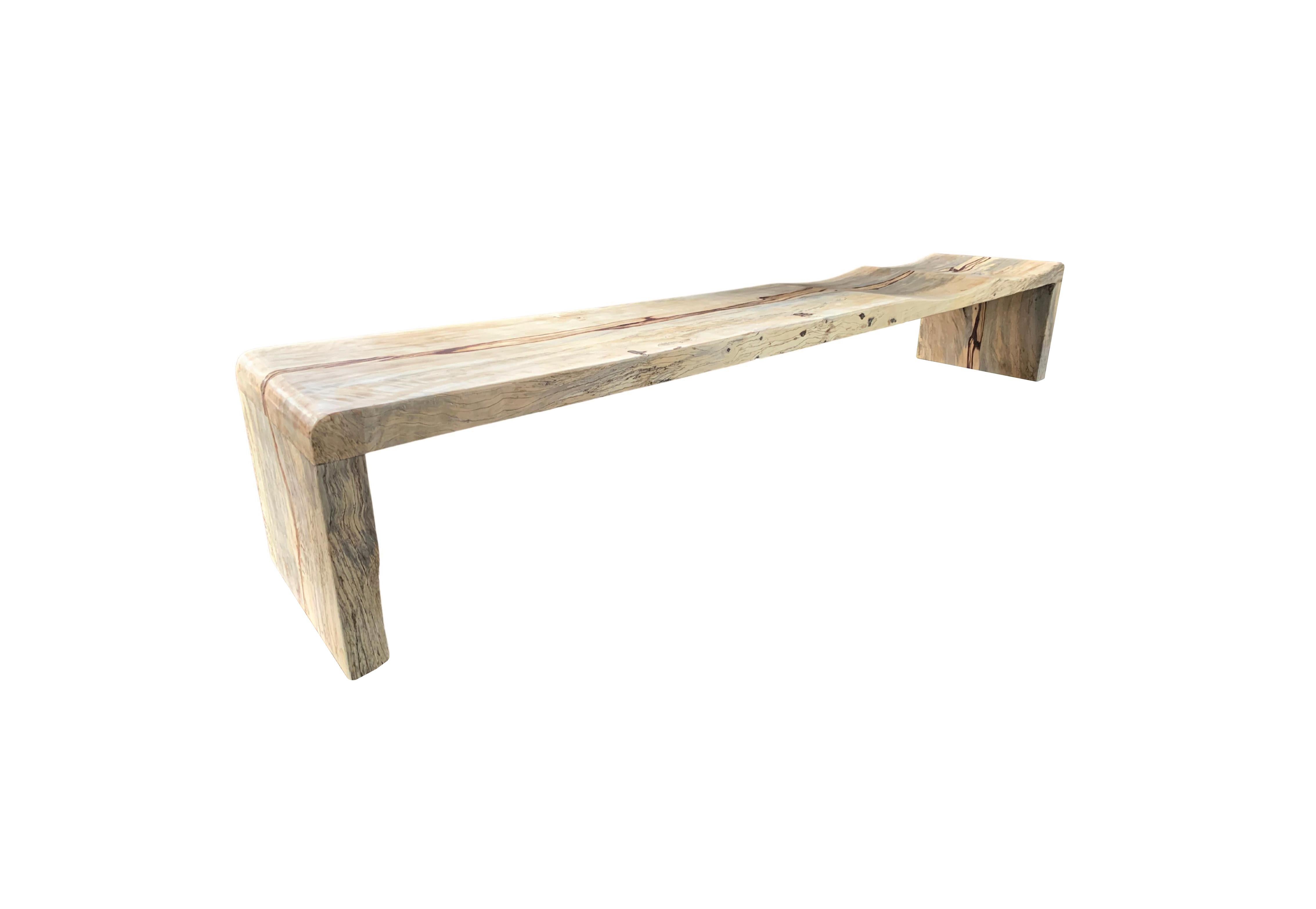 A sculptural hand-carved tamarind wood bench. The mix of curved and straight lines along with a myriad of textures make for a very elegant bench. Unique to this bench is the wood textures that resemble marble. One end of this bench features two