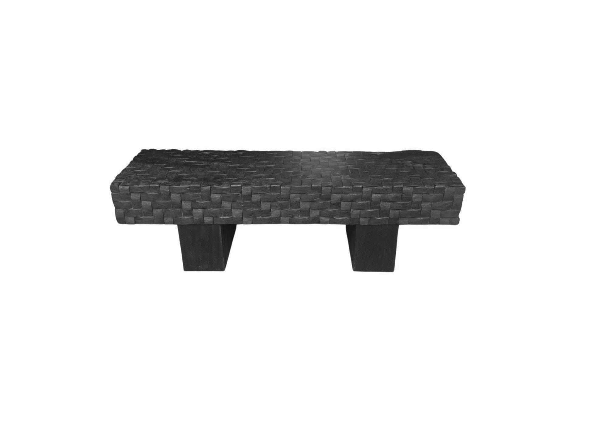Banc sculptural en bois de manguier sculpté à la main. Pour obtenir un pigment noir riche, le banc a été brûlé trois fois, puis recouvert d'une couche de vernis. Le mélange de lignes courbes et droites ainsi qu'une myriade de textures en font un