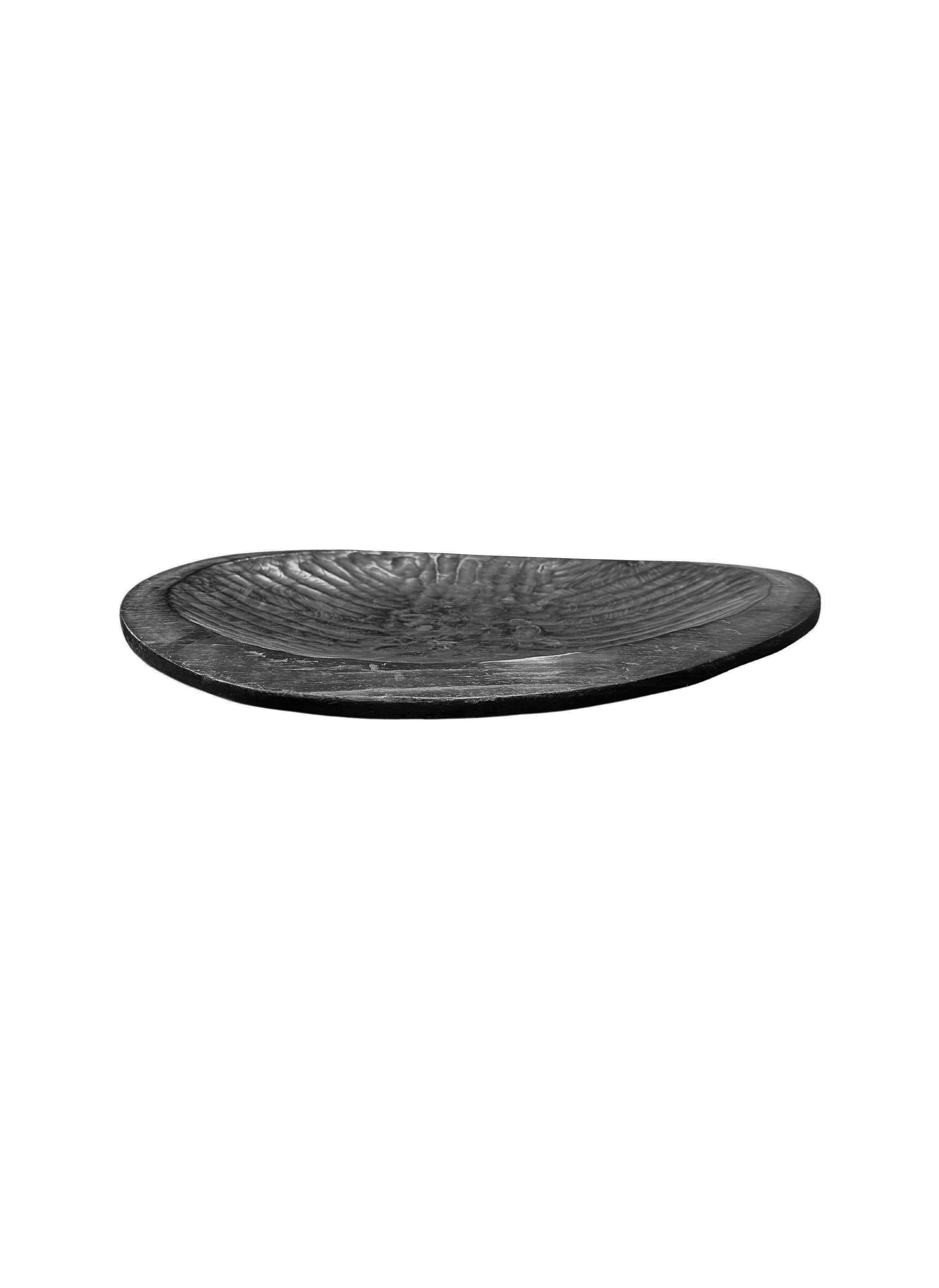 A hand-crafted mango wood bowl with hand-hewn detailing along the basin. The bowl was cut from a much larger slab of mango wood and features wonderful mix of wood textures. To achieve the rich black colour the bowl was burnt three times and finished