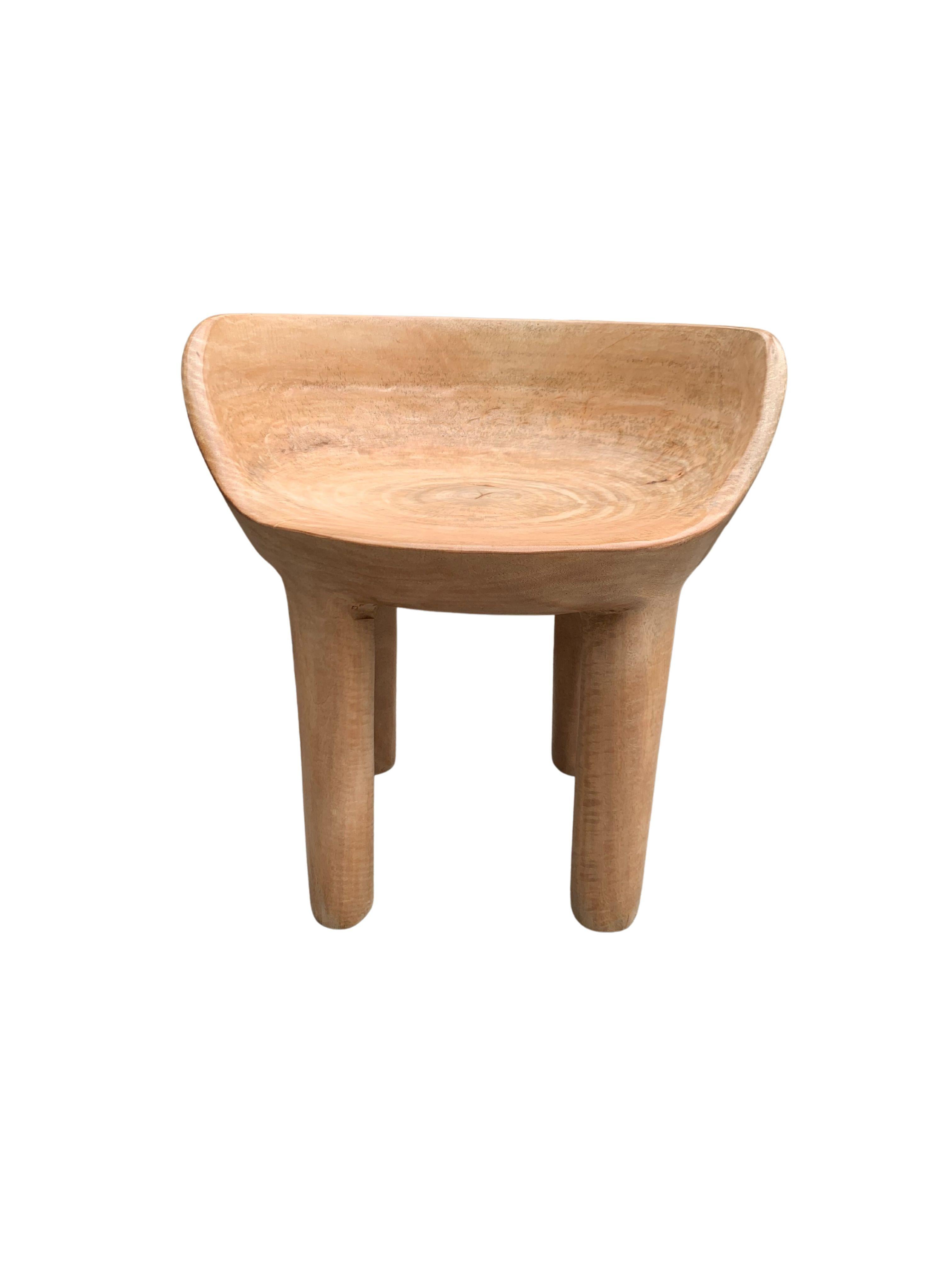 This wonderfully sculptural chair was crafted from a single block of mango wood. The chair sits on 4 slender legs. Its neutral pigment makes it perfect for any space. A uniquely sculptural and versatile piece certain to invoke conversation. This