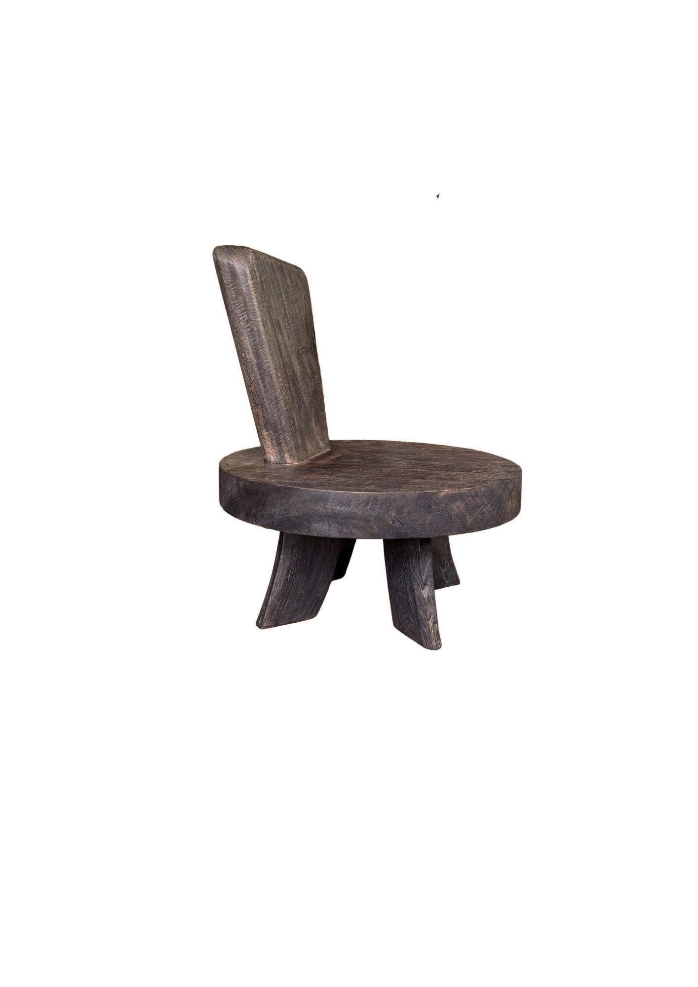 Bold in form and rich in texture, this sculptural chair is hand-crafted from solid mango wood, showcasing the organic beauty of its natural grain. The generous circular seat and dramatically angled backrest offer both visual interest and unexpected