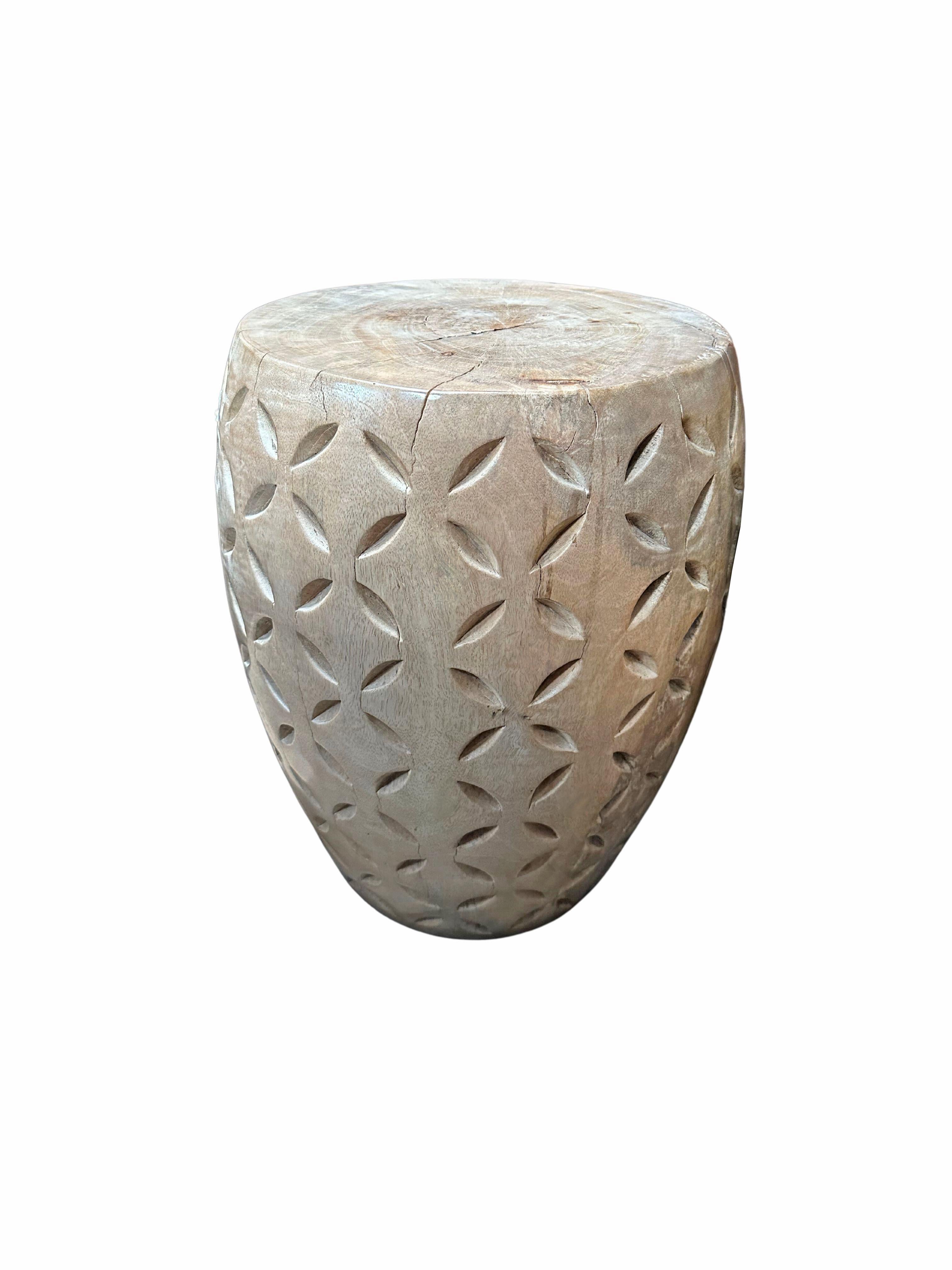 A wonderfully sculptural side table crafted from solid mango wood. It features a natural finish where the exterior was sanded and smoothed. The table features a wonderful mix of wood textures and shades. Unique to this table is the 