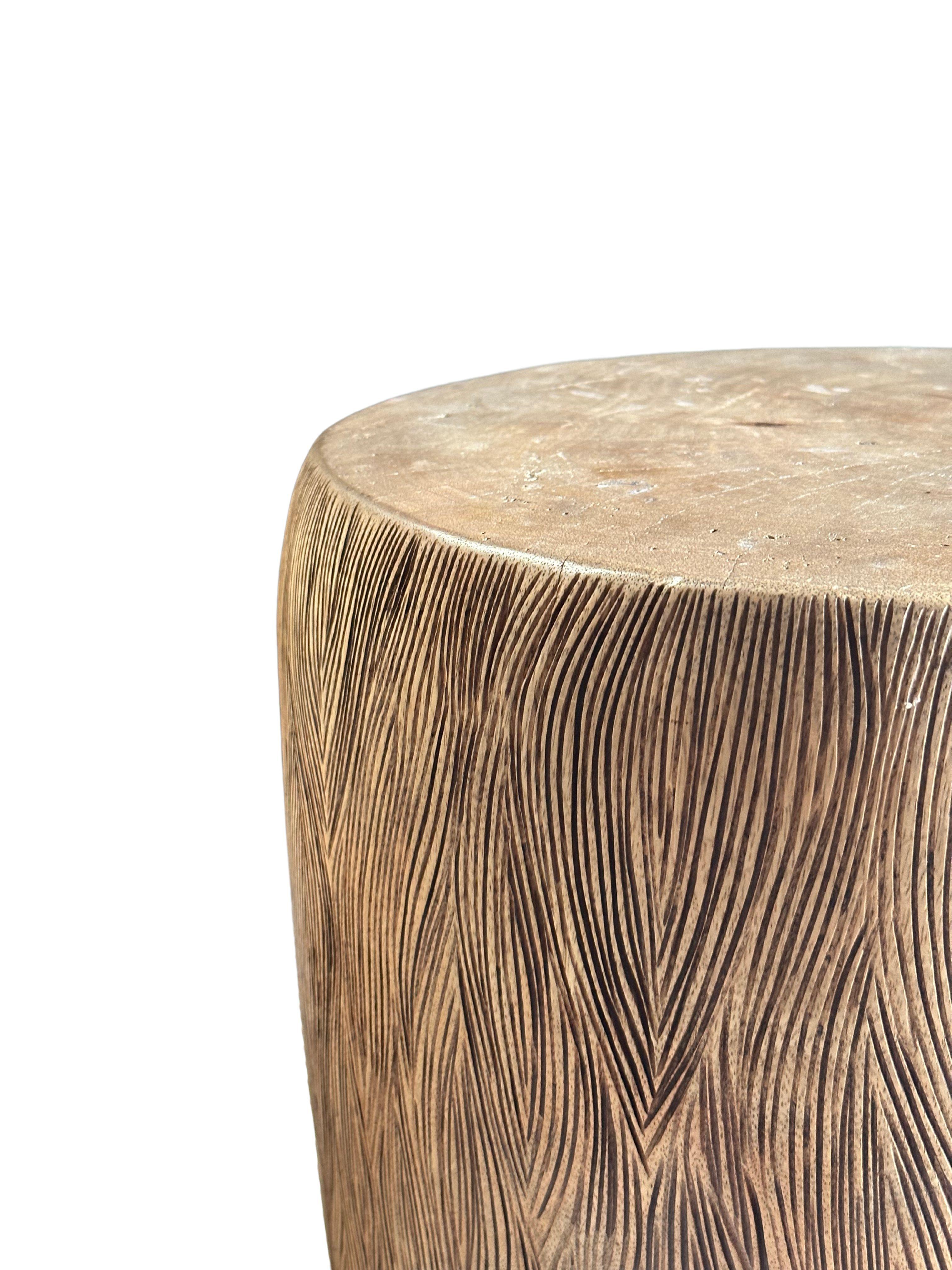 A wonderfully sculptural side table crafted from solid mango wood. It features a natural finish where the exterior was sanded and smoothed. The table features a wonderful mix of wood textures and shades. The perfect object to bring warmth to any