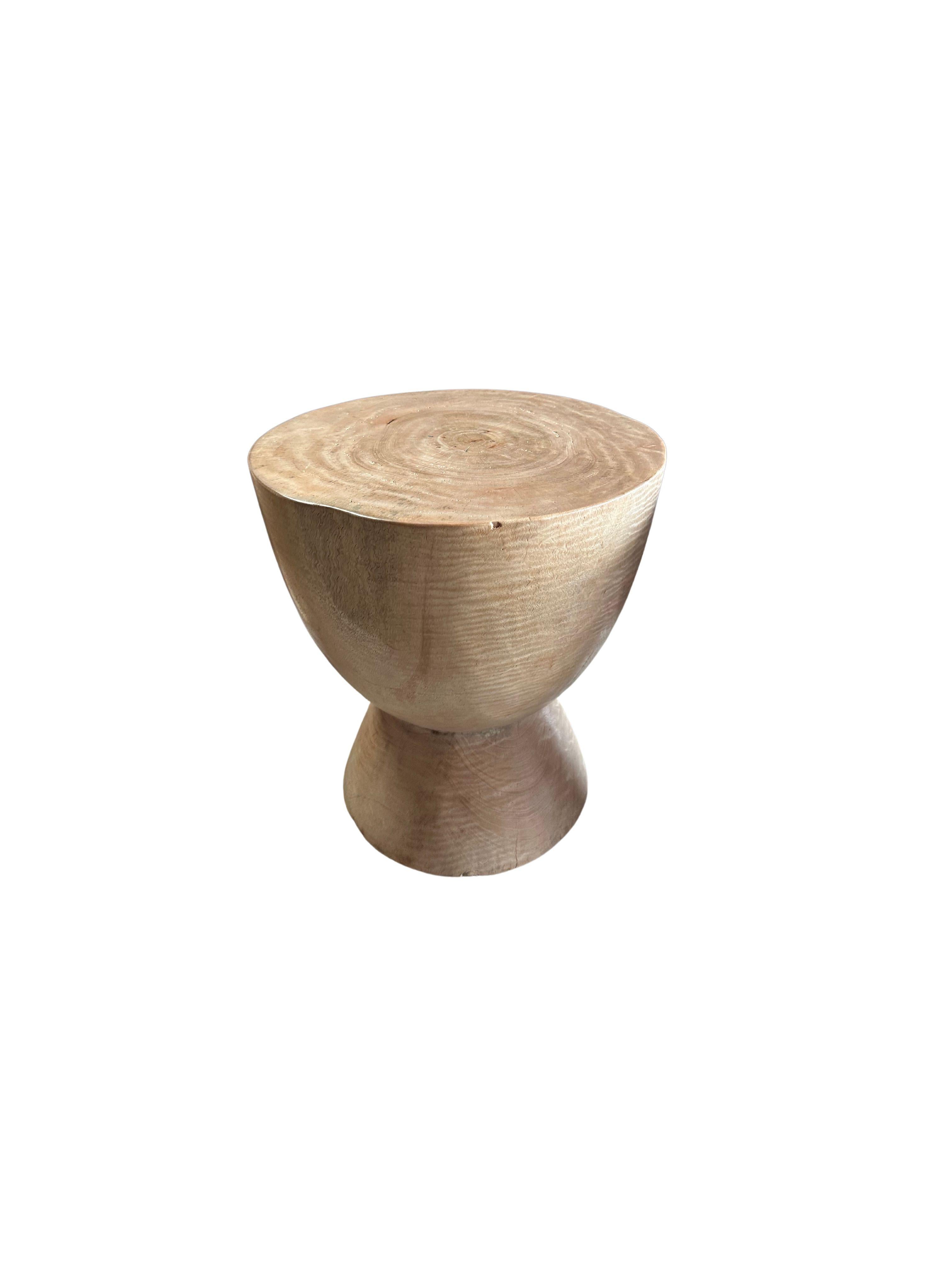 A wonderfully sculptural side table crafted from solid mango wood. It features a natural finish where the exterior was sanded and smoothed. The table features a wonderful mix of wood textures and shades. The perfect object to bring warmth to any