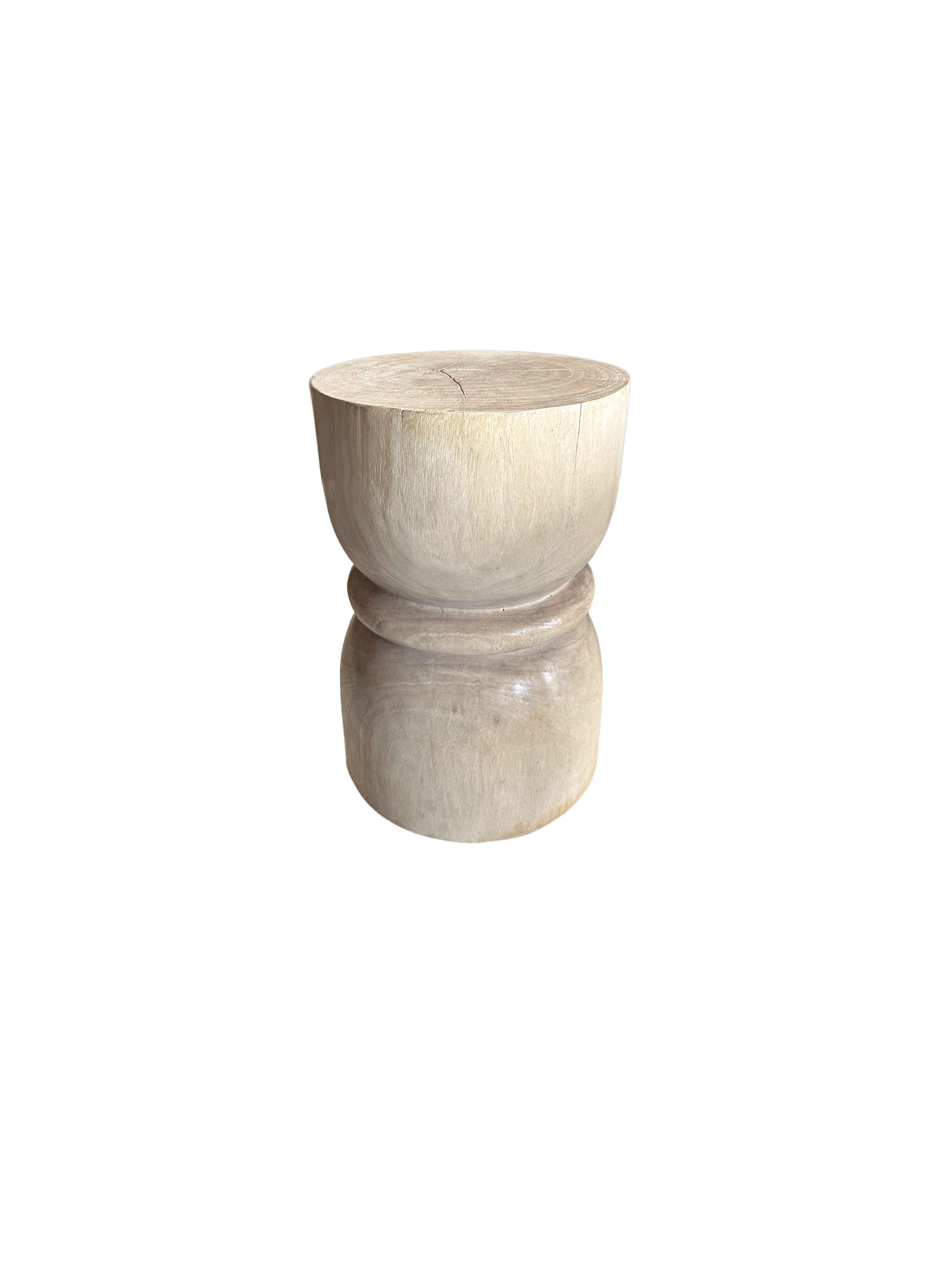 A wonderfully sculptural side table crafted from solid mango wood. It features a natural finish where the exterior was sanded and smoothed. The table features a wonderful mix of wood textures and shades. To achieve its tones the wood was bleached