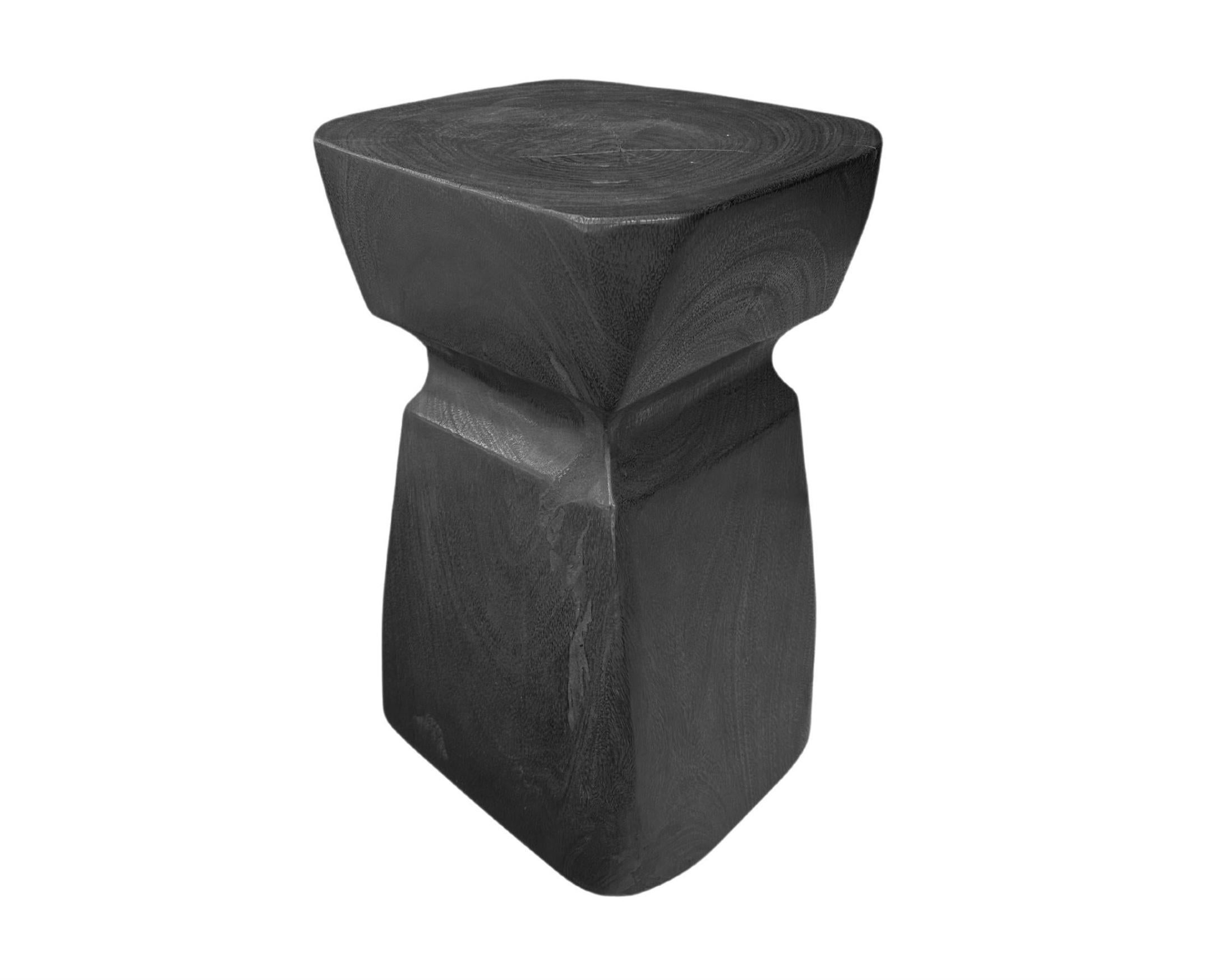 A wonderfully sculpted side table, crafted from a single block of mango wood. It features wonderful wood textures. To achieve its black finish the wood was burnt several times and finished with a clear coat. This item was carved by skilled artisans