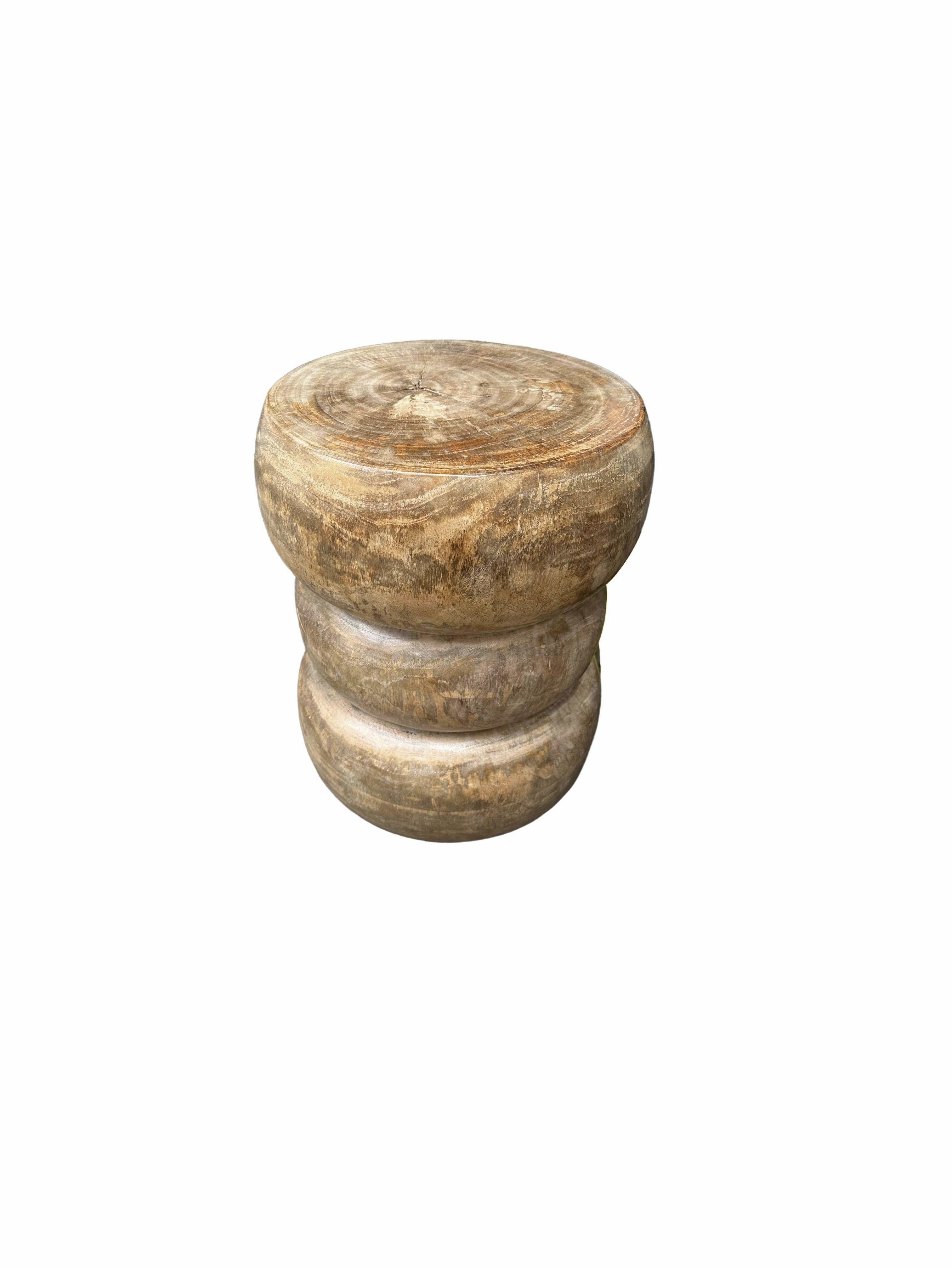 A wonderfully sculptural side table crafted from solid mango wood. It features a natural finish where the exterior was sanded and smoothed. The table features a wonderful mix of wood textures and shades. The perfect object to bring warmth to any