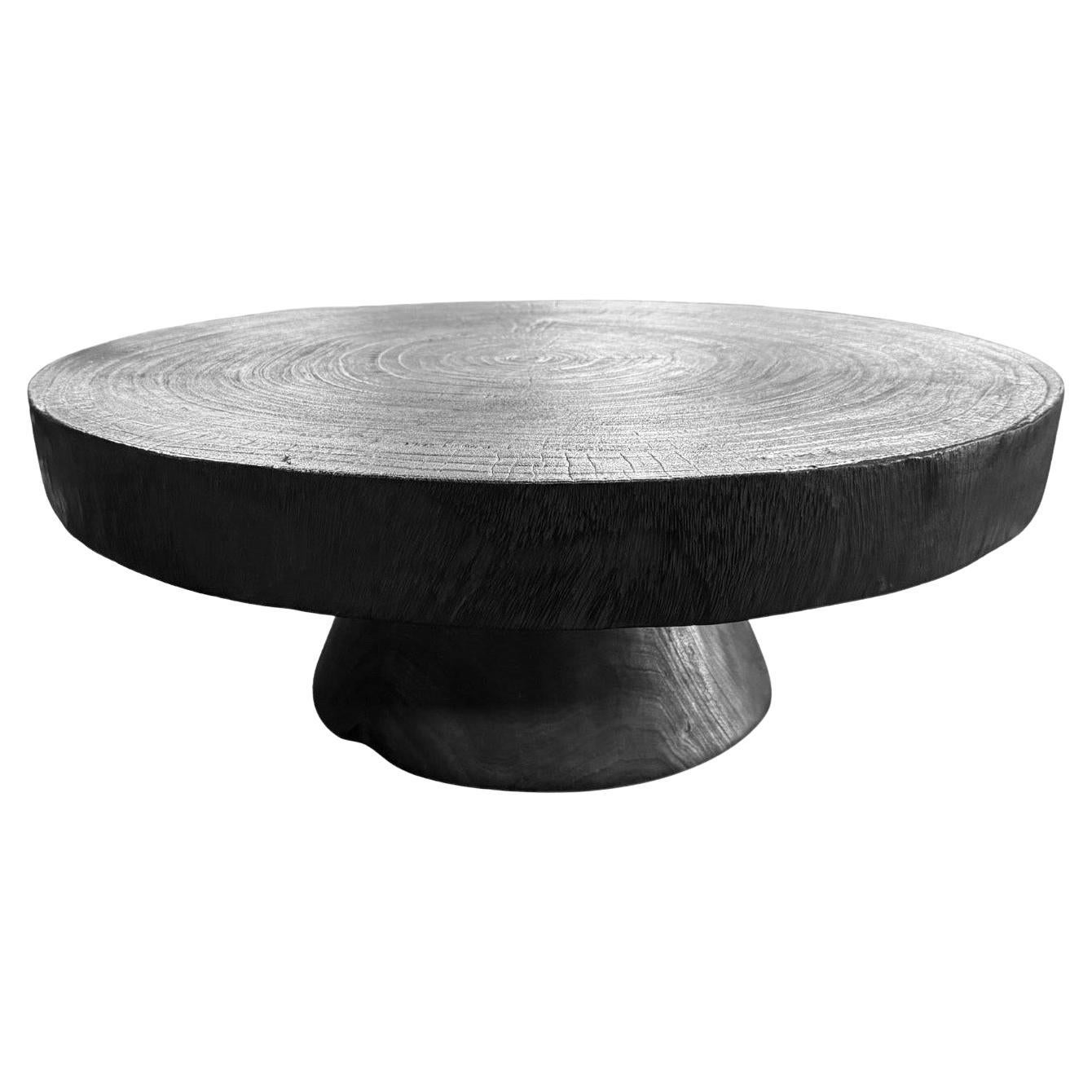 Tavolo scultoreo in legno di mango realizzato in legno massiccio di suar, finitura bruciata