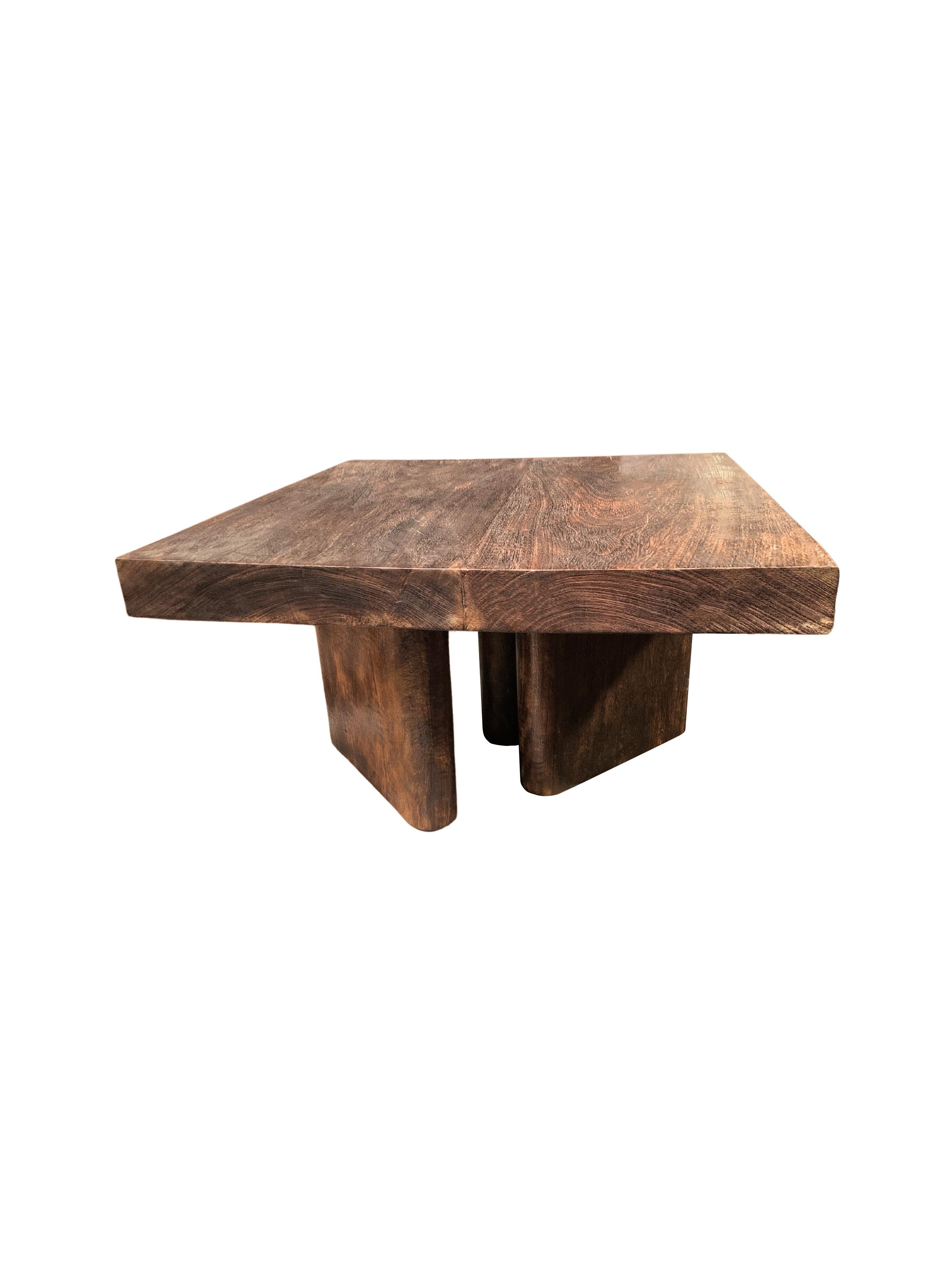 A sculptural mango wood bench with an espresso pigment. The mix of curved and straight lines and subtle wood texture make for a very elegant table. Unique to this bench are the 3 angular legs it sits on. These legs feature curved edges to provide