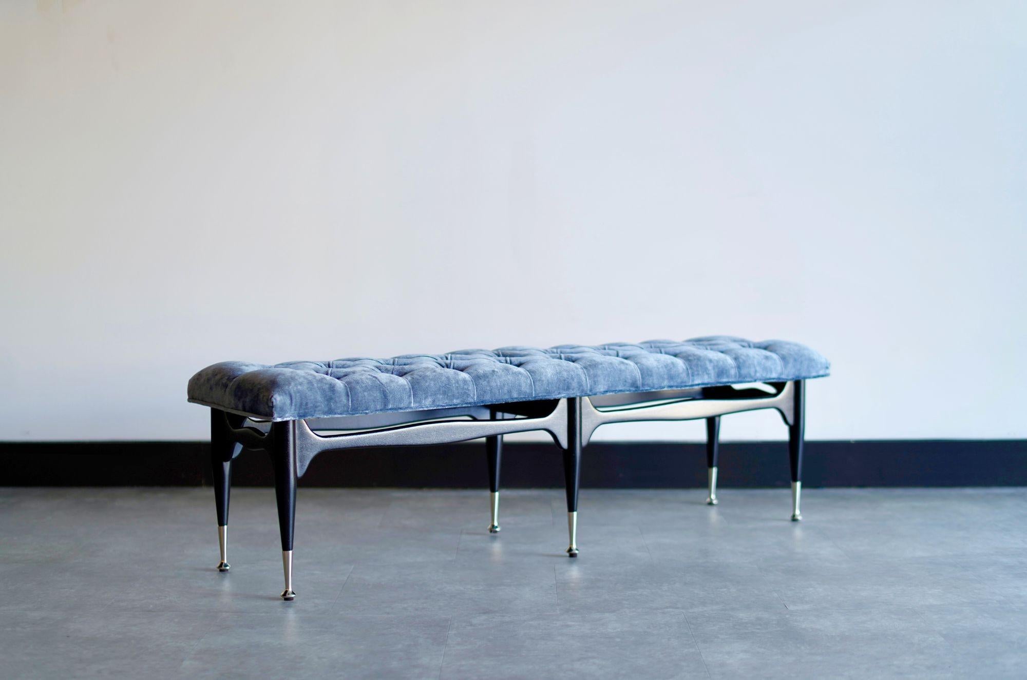 An original 1950s mid-century modern tufted bench, meticulously restored to its former glory by Stamford Modern. Crafted from solid new ebonized mahogany, this timeless beauty boasts impeccable craftsmanship, complemented by nickel sabots and a
