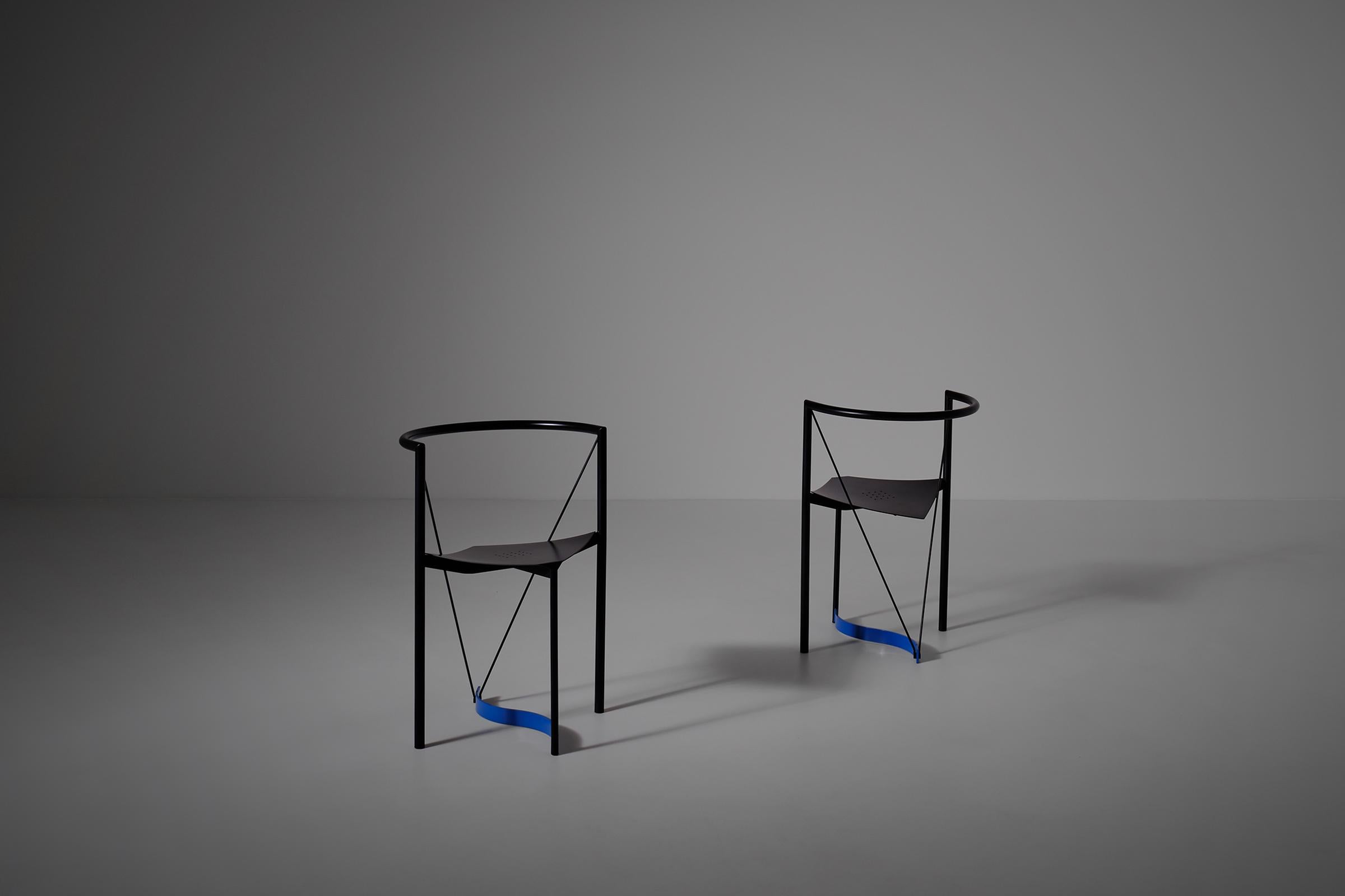 Set of two side chairs, 1980s. The chairs are constructed out of a black lacquered tubular steel frame and have a square perforated shaped seating, the curved blue connection line creates and interesting eye catching detail. The radical shapes used