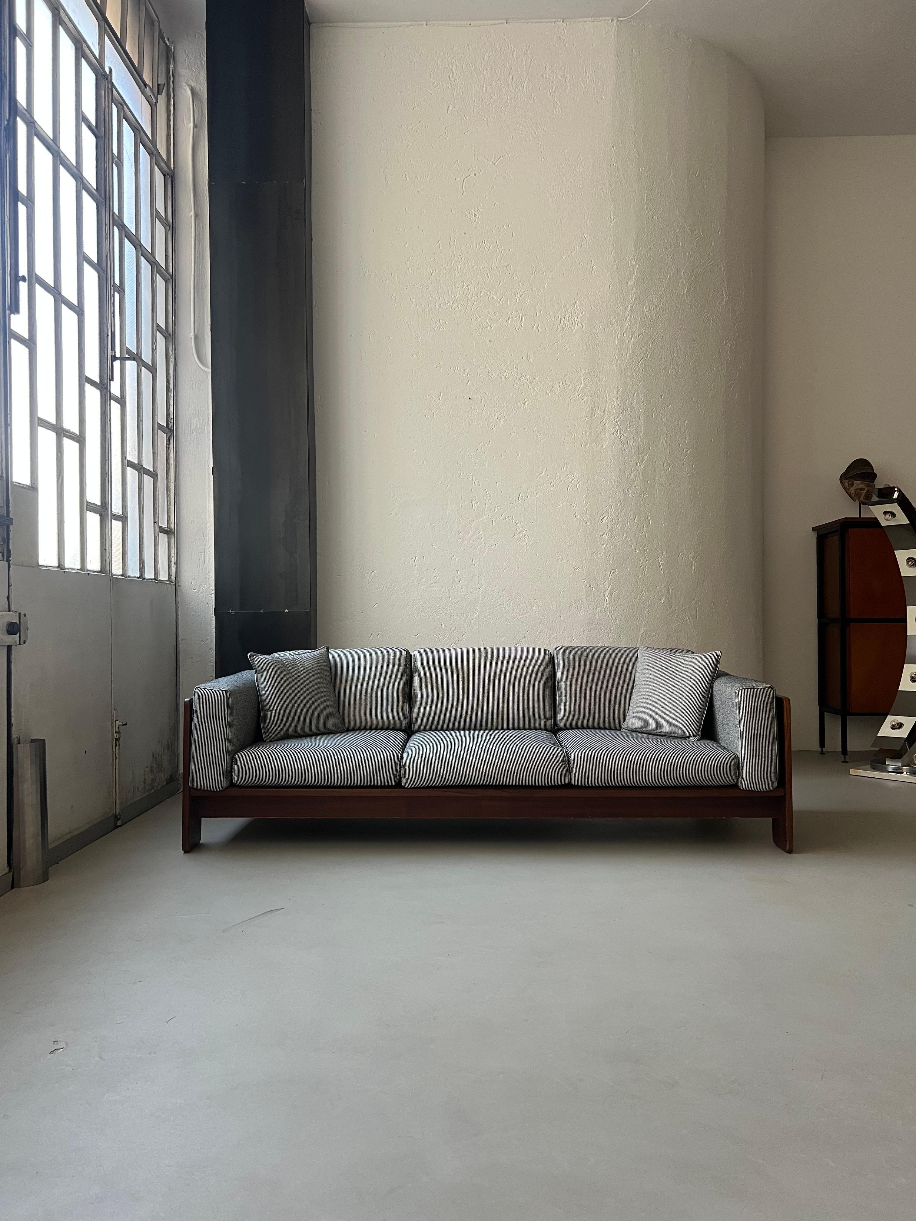 Disegnato da Afra & Tobia Scarpa nel 1962, Bastiano è un divano scultoreo che esprime al meglio la filosofia di design della coppia. Gli elementi che li contraddistinguono - struttura geometrica in legno, morbido tessuto italiano di prima qualità,