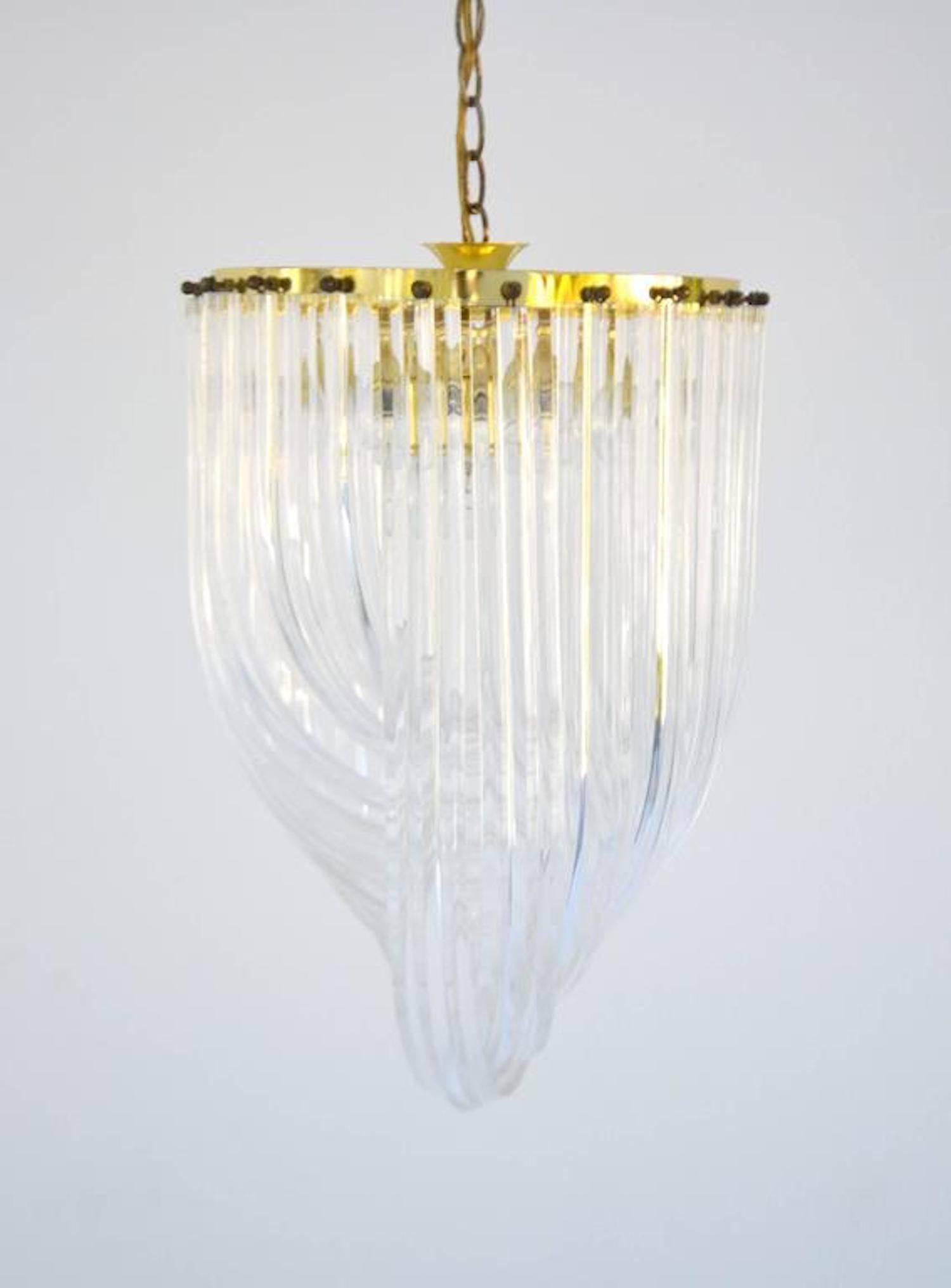 Glamorous midcentury acrylic crystal rod chandelier, circa 1960s-1970s. This sculptural round chandelier is designed of intertwining loops of clear twisted Lucite rods suspended from a brass frame.

Measurements:
Overall: 14