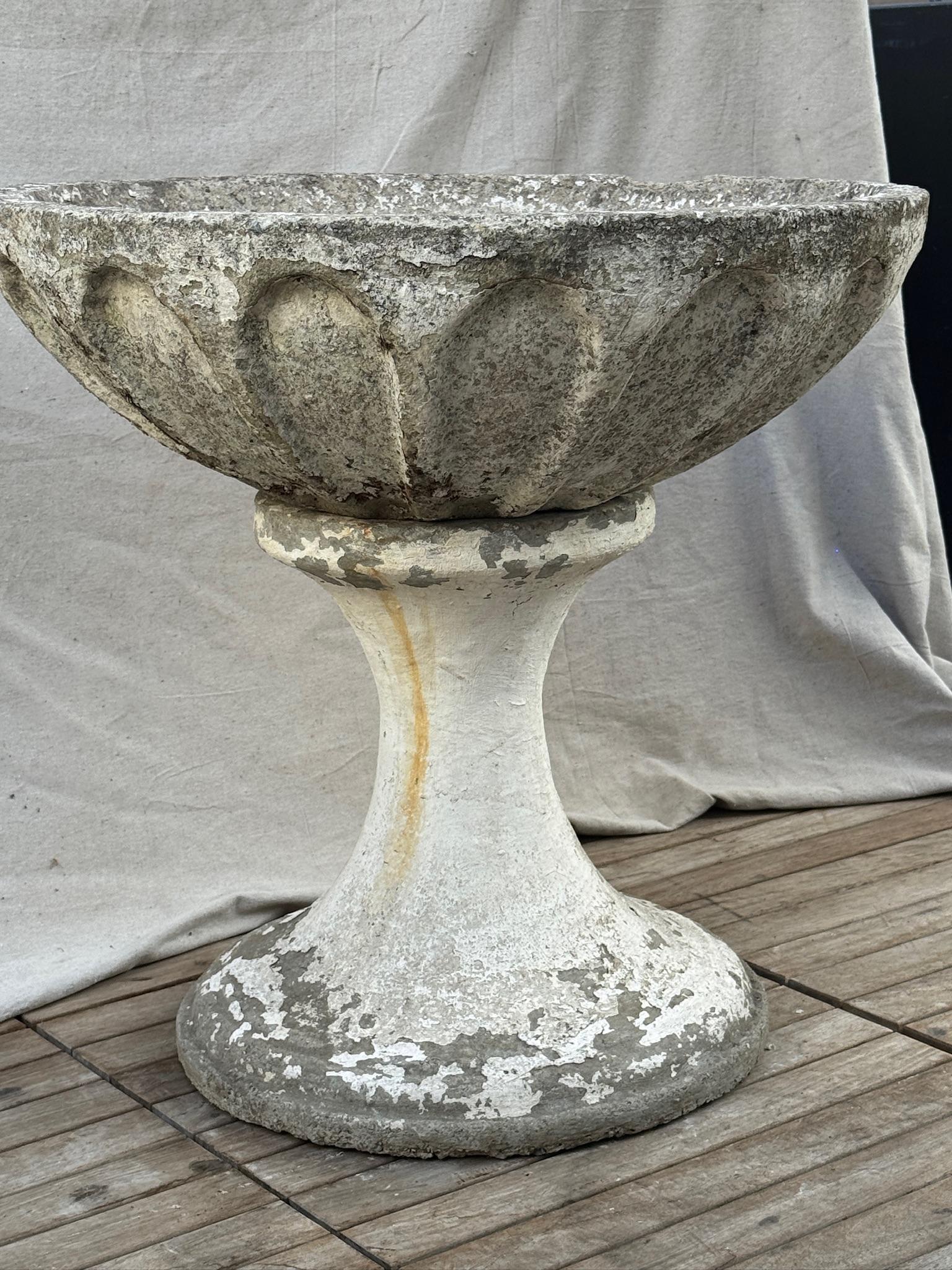 This exceptional two-piece mid-century concrete garden planter features a bold sculptural profile with a deeply fluted bowl set atop a flared pedestal base, creating a commanding architectural presence. Likely dating from the 1950s to 1970s, the