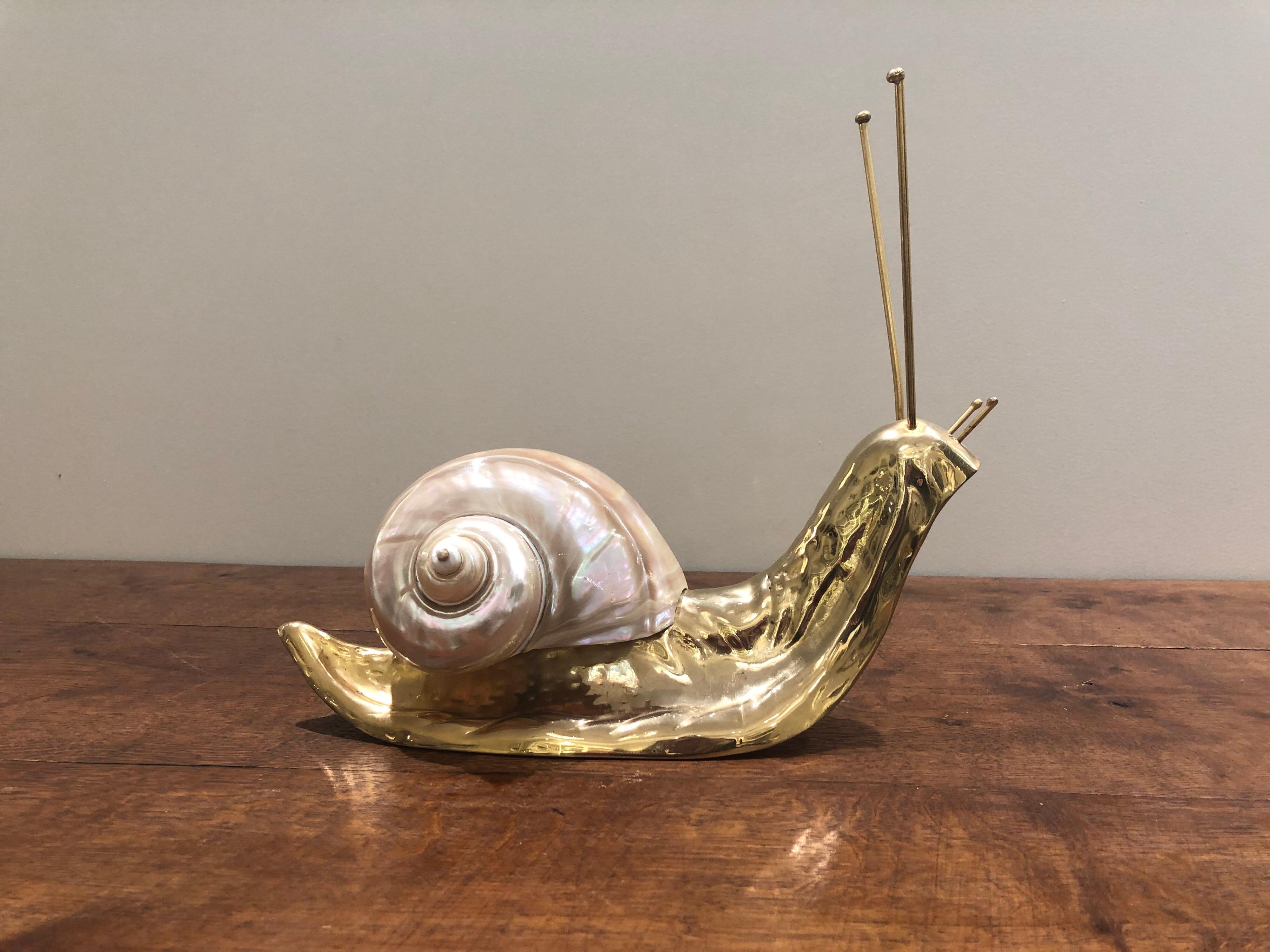 A charming decorative Italian nautical midcentury 1970s brass sculpture of an escargot with a conch shell on its back. The snail is beautifully detailed with a curved body and antennae.