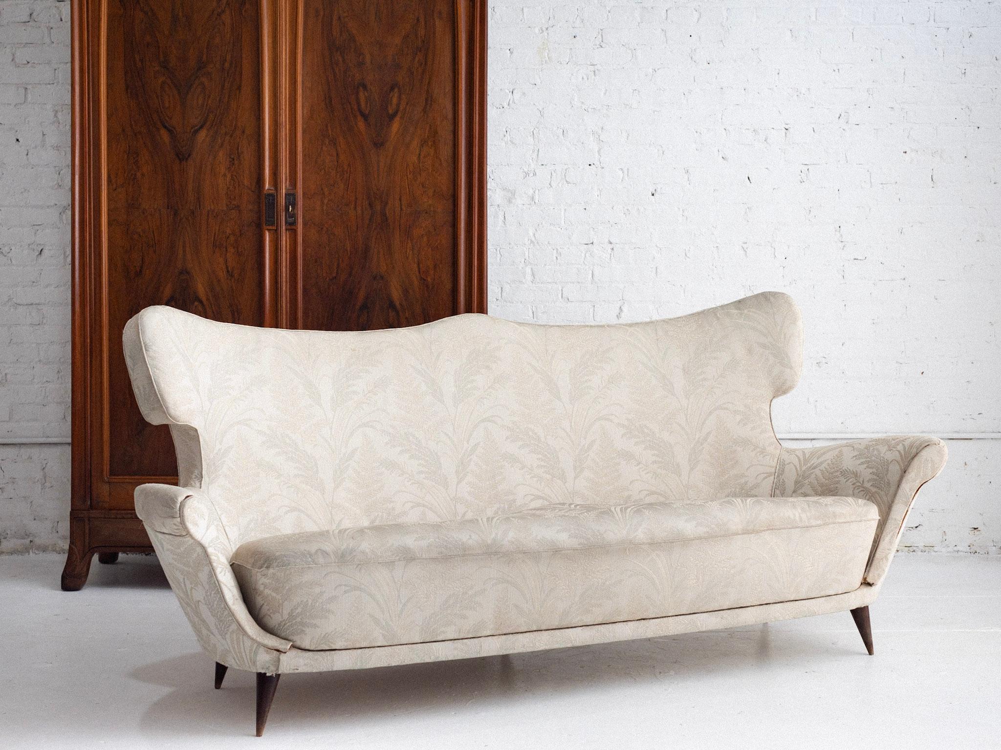 A mid century Italian sofa attributed to Maurizio Tempestini. Sculptural wingback silhouette. Original upholstery as found. Sourced in Northern Italy.