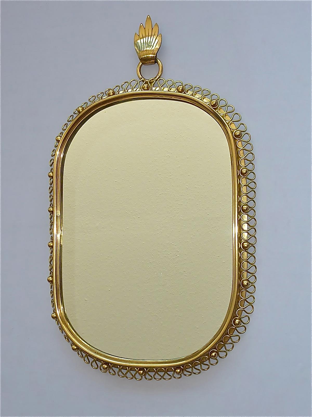 Sculptural mid-century wall mirror designed by Austrian Josef Frank and manufactured by Svenskt Tenn, Sweden in the 1950s. The mirror is made of patinated brass with an ondulation spiral loop frame with round solid brass screw nuts around. The