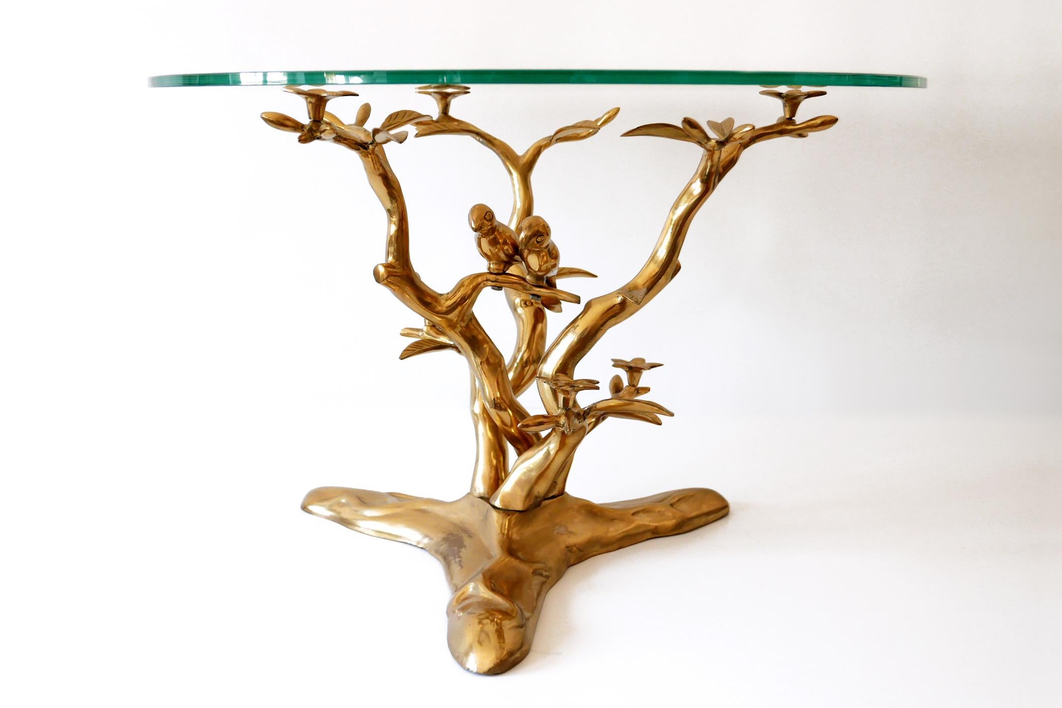 Very beautiful and highly decorative Mid-Century Modern coffee table with a massiv brass base in form of tree with two loving birds. Designed by Willy Daro, Belgium, 1970s.

Executed in massiv brass base and clear glass top.

Dimensions: 
Dm