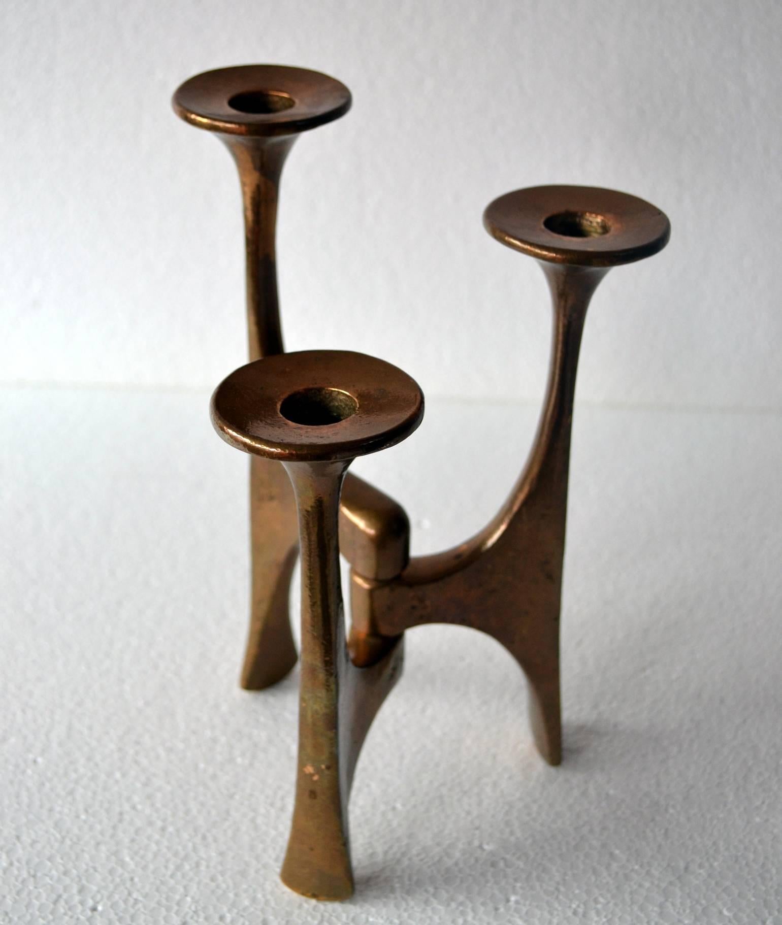 Bronze cast freeform candelabra with soft curves and lines. Three arms on descending heights hold regular size candles.