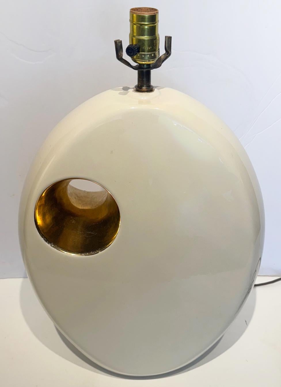 Sculptural Mid century Modern Ceramic Table Lamps with Gold Accents, Pair

Offered for sale is a pair of sculptural mid century modern glazed ceramic table lamps. The lamps are glazed Ivory in tone with a circular cutout highlighted in 24K gold. One