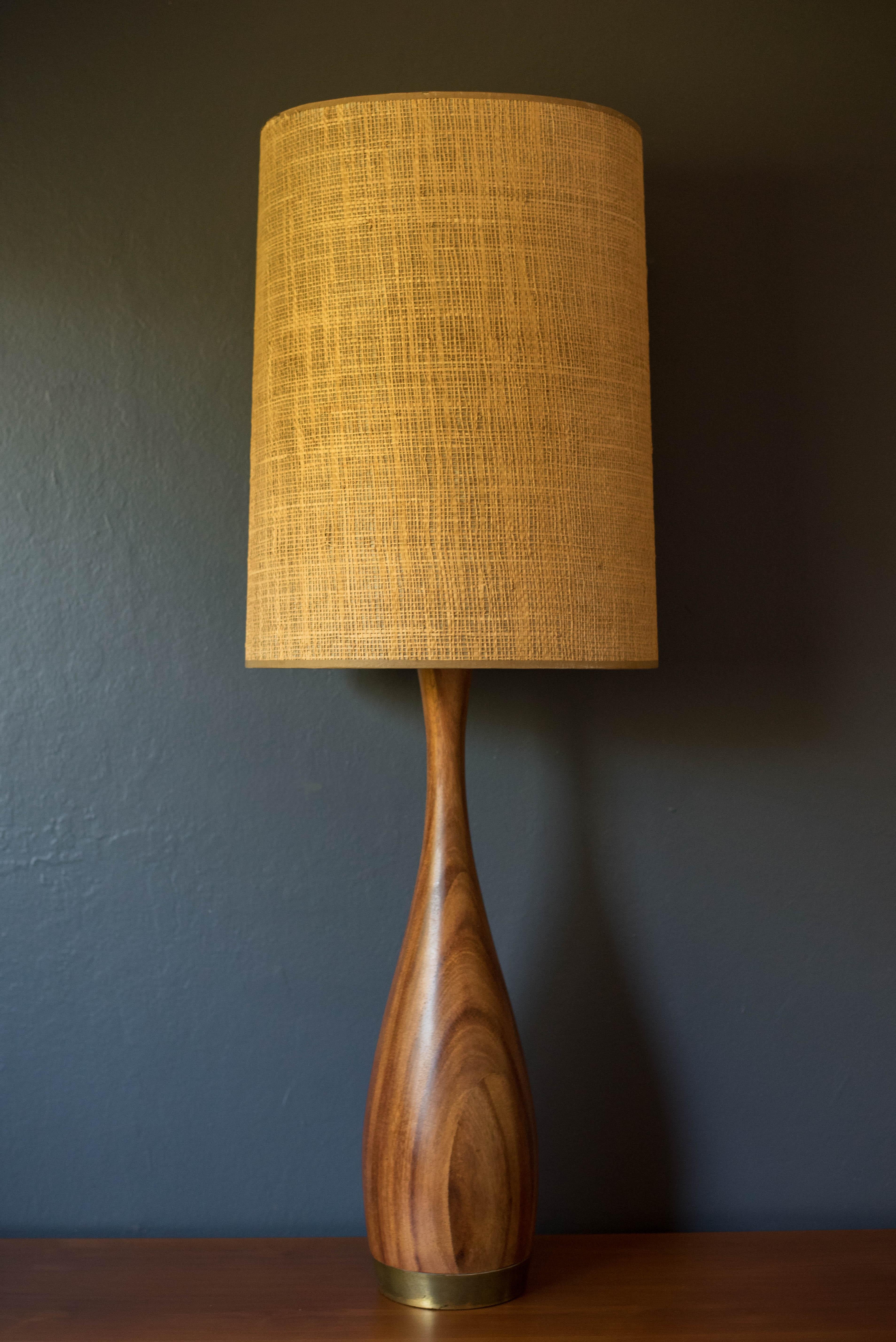 Lampe de table d'appoint haute, moderne du milieu du siècle, circa 1960. La base sculpturale en bois d'acajou est rehaussée d'une quincaillerie en laiton. Cette pièce est équipée d'un variateur de lumière. L'abat-jour n'est pas inclus.