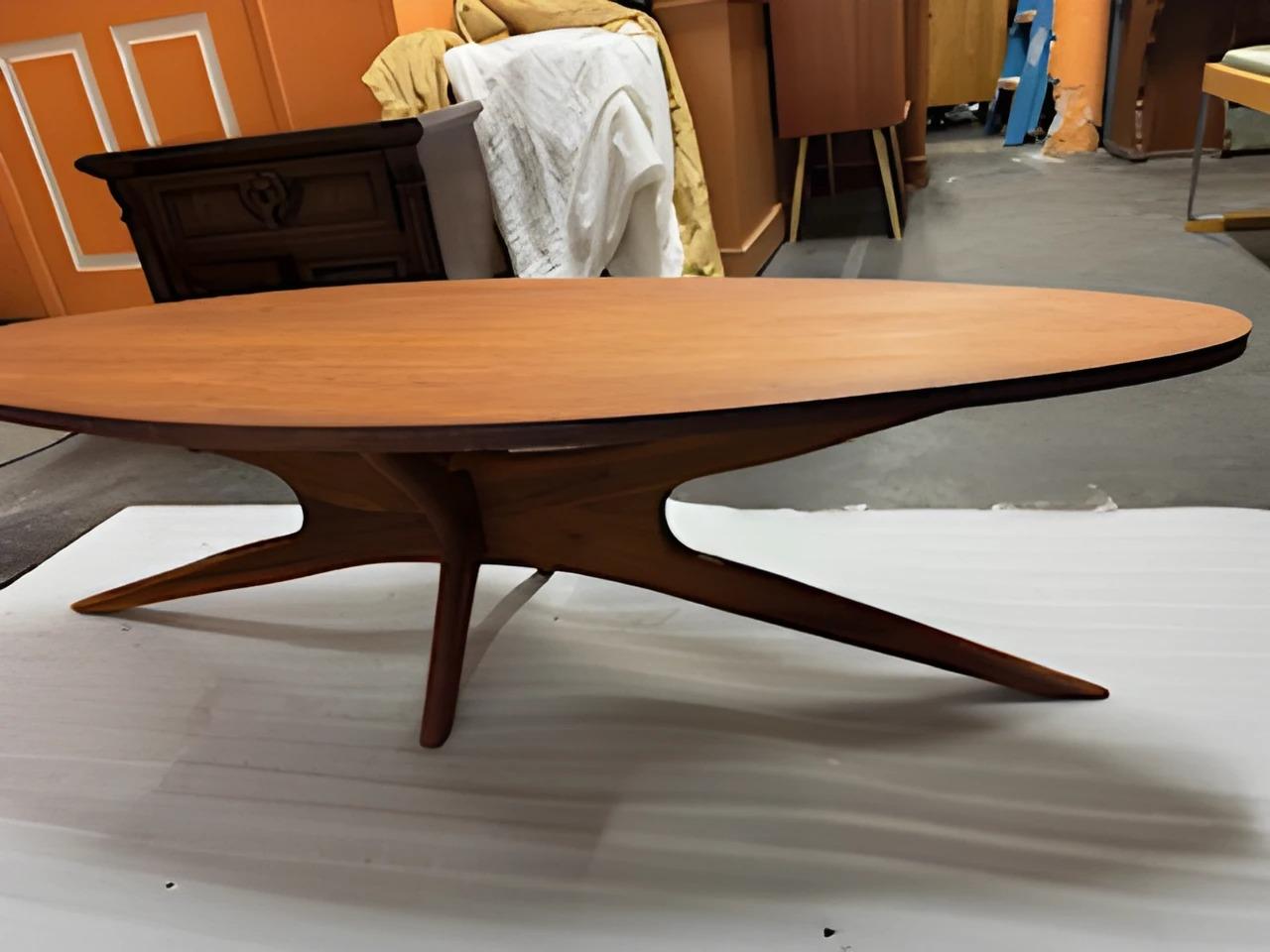 Mid century modern coffee table with sculpted base. This has all of the characteristics of an Adrian Pearsall down to the structure and dimensions except for we’ve never seen a wood top. We have heard he did a lot of custom work so who knows! The