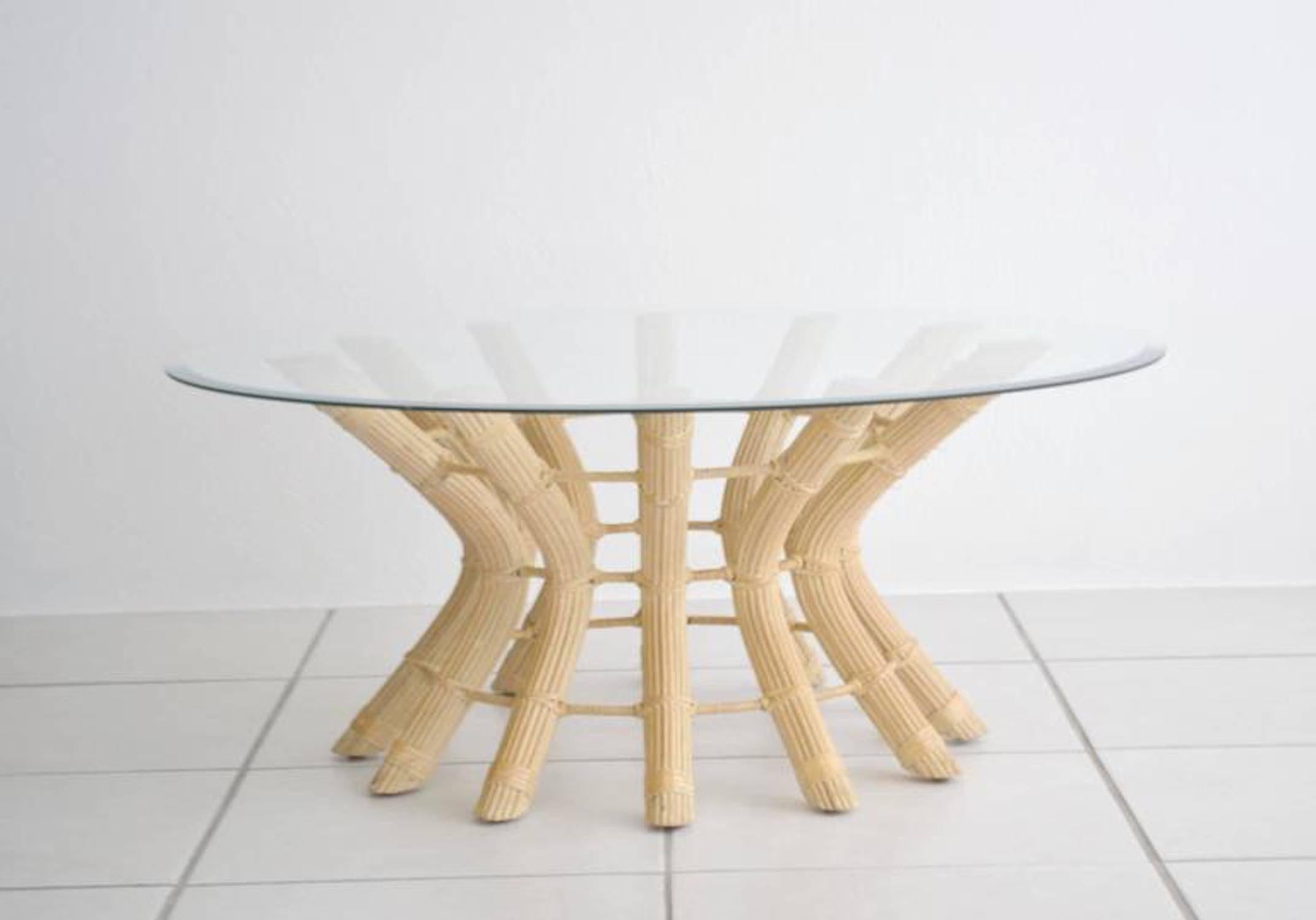 Striking midcentury sculptural rattan cocktail table, circa 1960s-1970s. This exquisitely crafted round coffee table is designed of bleached cut rattan strips over an undulating metal frame with leather wrapped joints. The table is accented with a