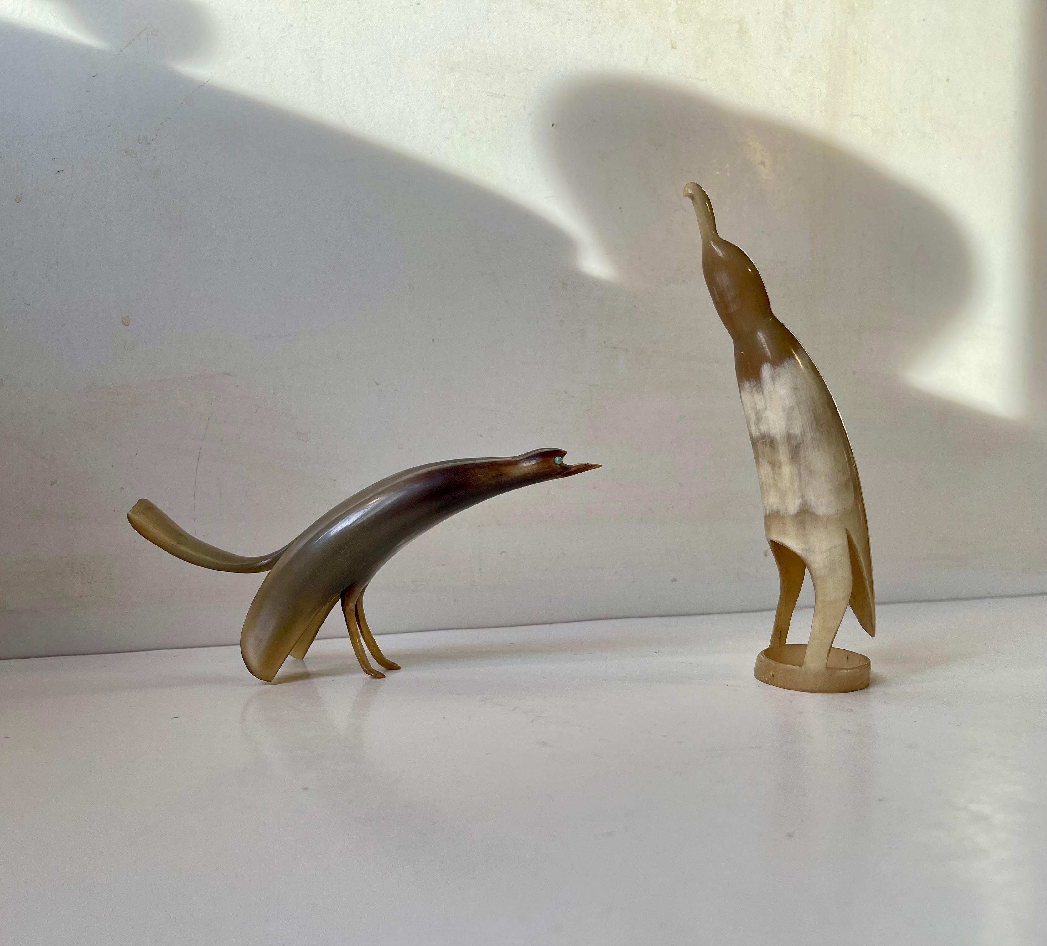 Petites figurines d'oiseaux faites à la main et sculptées dans de la corne de bœuf. L'un d'entre eux représente un petit œil de verre vert et l'autre un oiseau un peu plus abstrait ou librement interprété. Néanmoins, il s'agit d'un ensemble