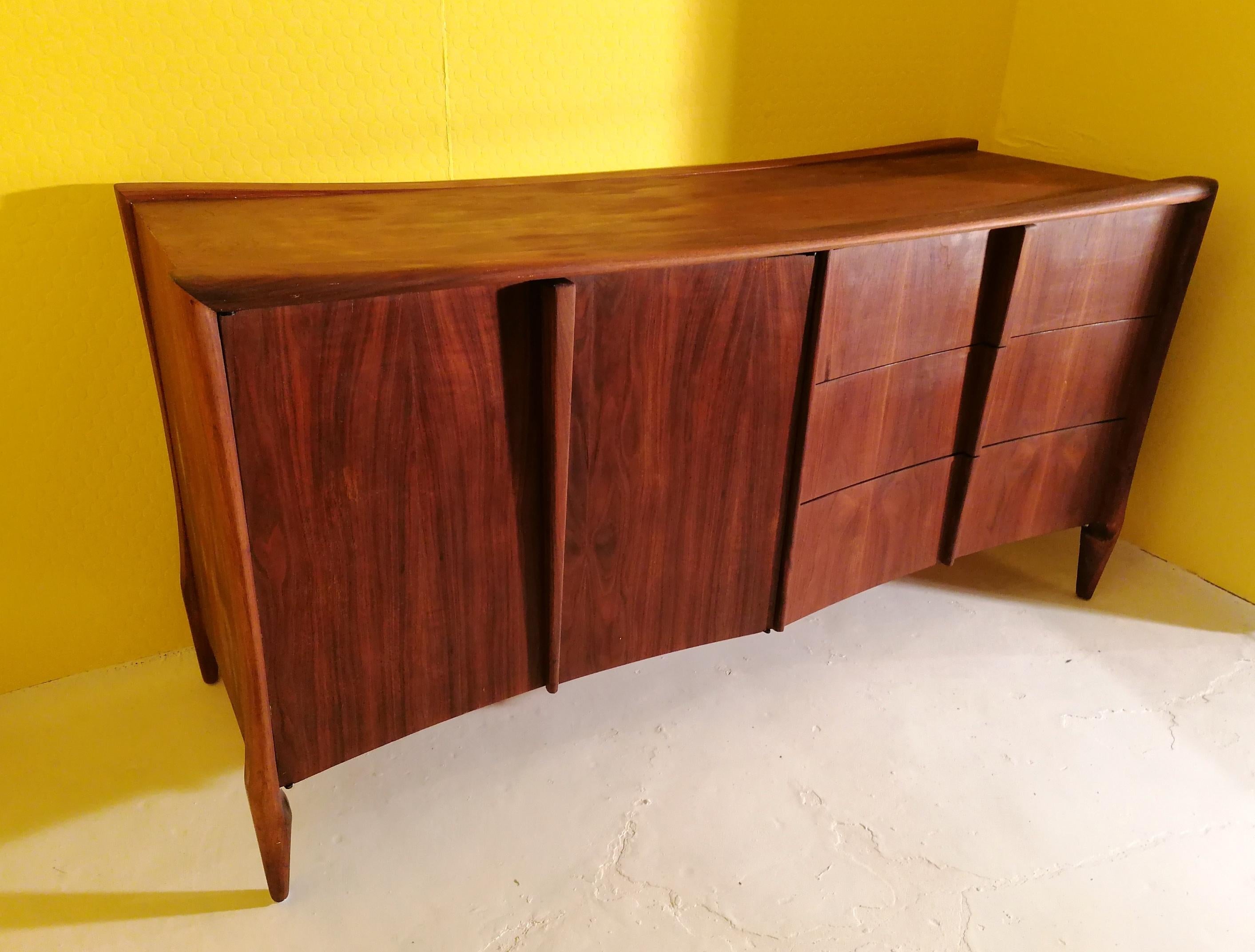 Beautiful sculptural walnut sideboard by Vanleigh New York, 1970s. 
The colour looks like rosewood in some of these photos for some reason, but it's not in reality. Has a subtle semi sheen oiled finish.
Doors on left open onto shelved storage, on