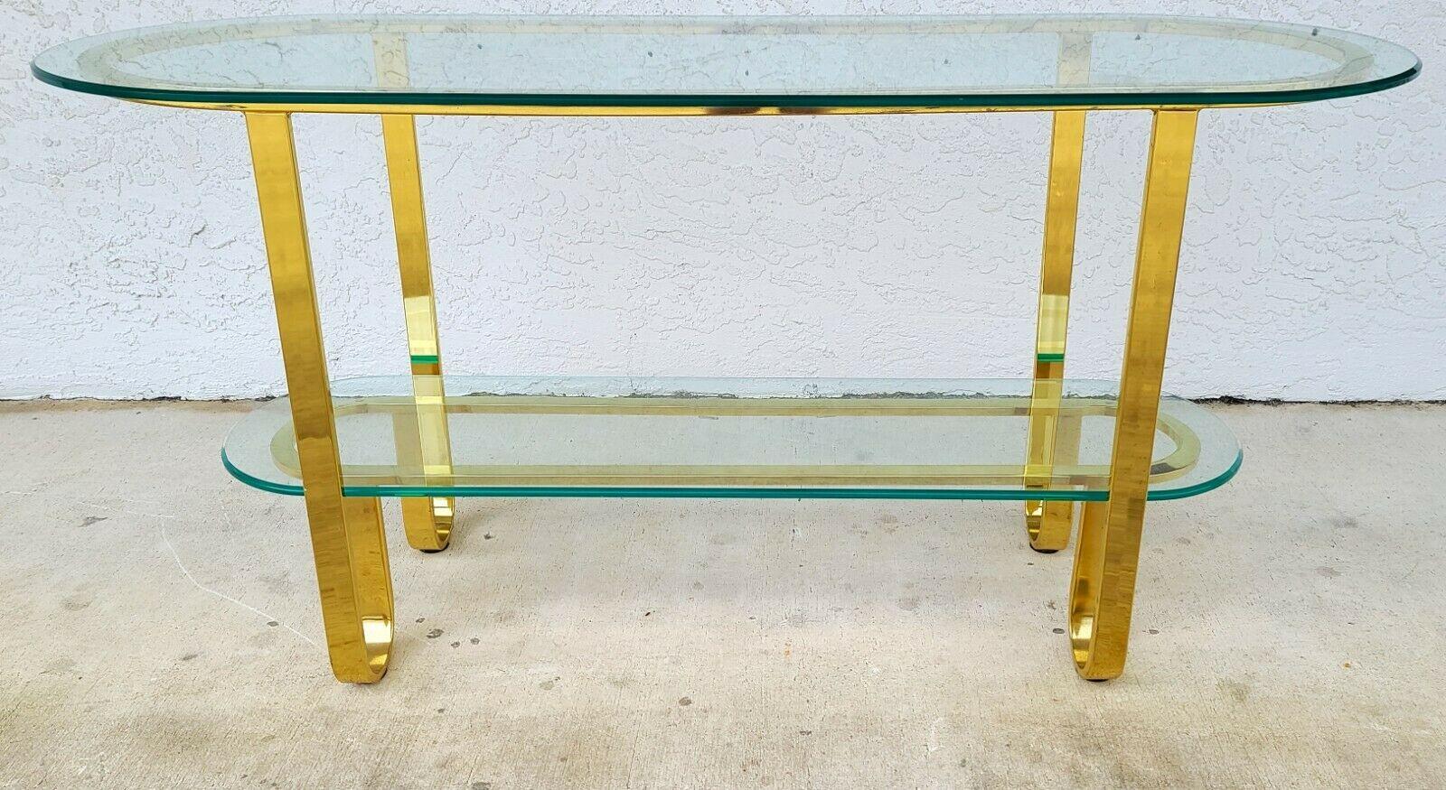 Offering one of our recent palm beach estate fine furniture acquisitions of a sculptural Milo Baughman style 2 tier brass & glass console sofa table 
With beveled edge glass shelves

Approximate measurements in inches
27