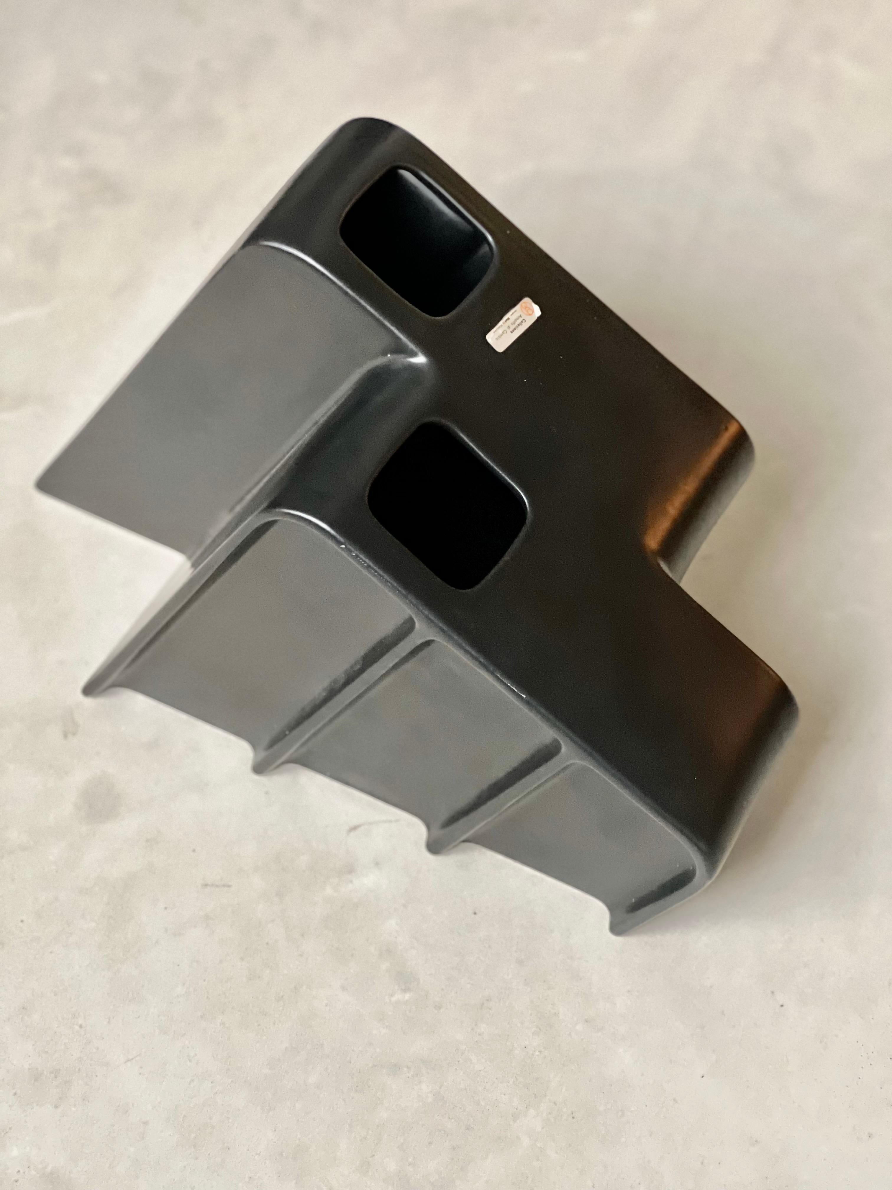 Macizo y raro jarrón de cerámica esmaltada fundida, vidriado en negro, fabricado en Italia y diseñado por Makio Hasuike,
la forma es racional y minimalista representando una arquitectura contemporánea realizada como una escultura de mesa que puede