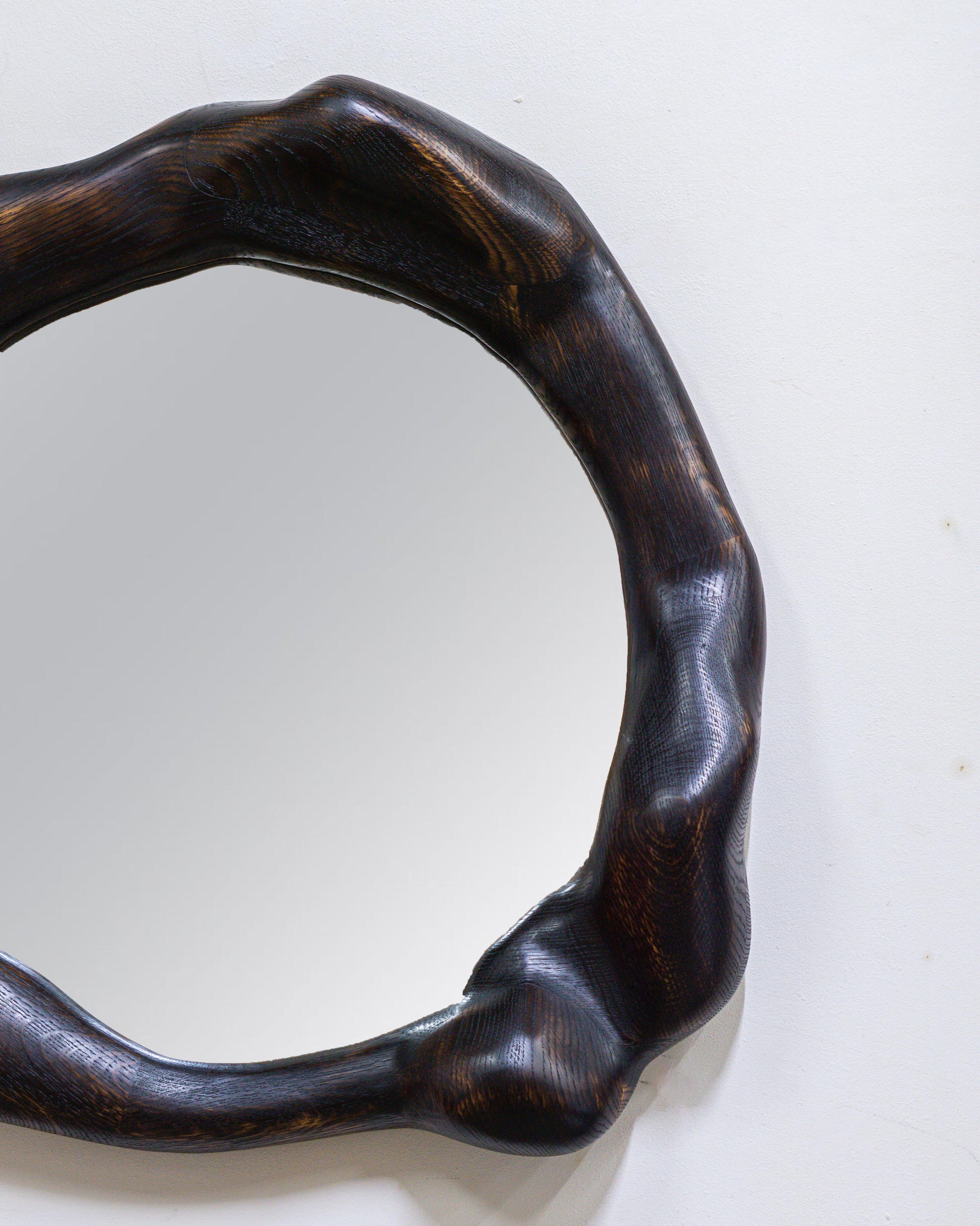 The frame of the mirror is shaped using various hand tools, making each piece unique with its own distinctive wood grain. The mirror is made from high-quality oak, which is lightly burned and finished with a hardwax oil.

The mirror is mounted on