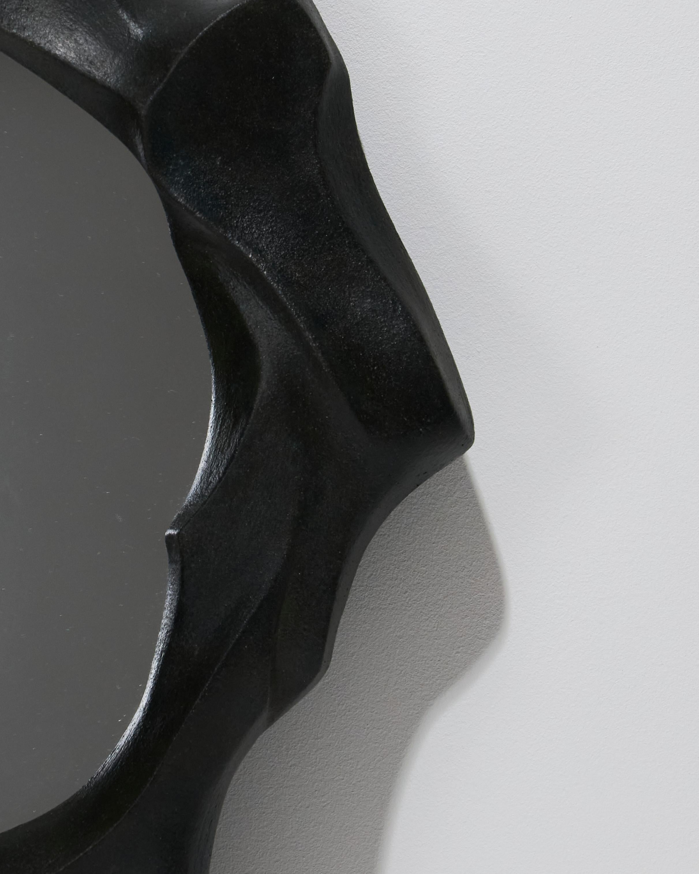 Specchio scultoreo in gres e ossidi, realizzato a mano dall'artista Camille Le Dressay. Un pezzo unico, firmato sul bordo. Questo specchio si distingue per la sua cornice in gres modellata in modo irregolare, che evoca la fluidità delle onde o delle