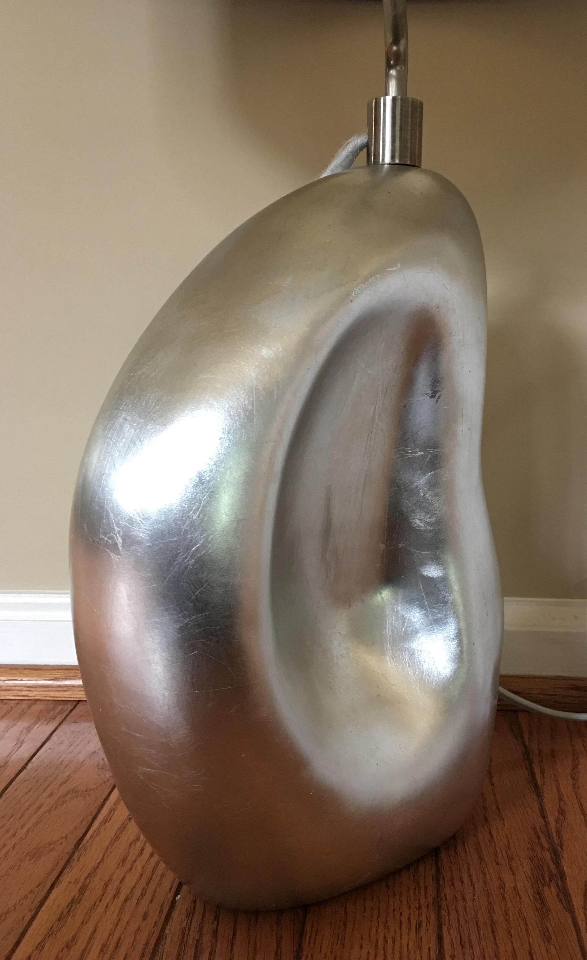 Modern organic sculptural Lenoir table lamp by Aerin Lauder for Visual Comfort Lighting. Biomorphic abstract base features a beautiful reflective burnished silver leaf finish. The brushed silver metal neck rotates/swivels to desired position.