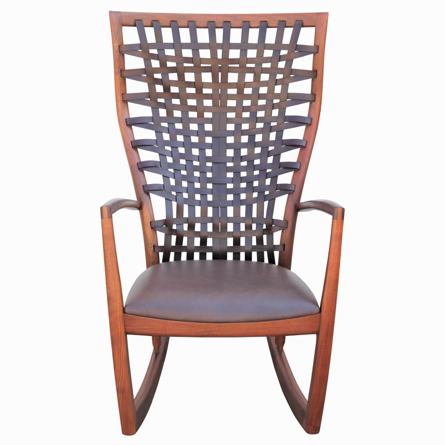 Exquisite handmade rocking chair made from walnut with a leather seat and woven leather backing. This sculptural rocking chair has a pair available. The maker, Roger Deatherage is a proudly lives and works in Houston, Texas.