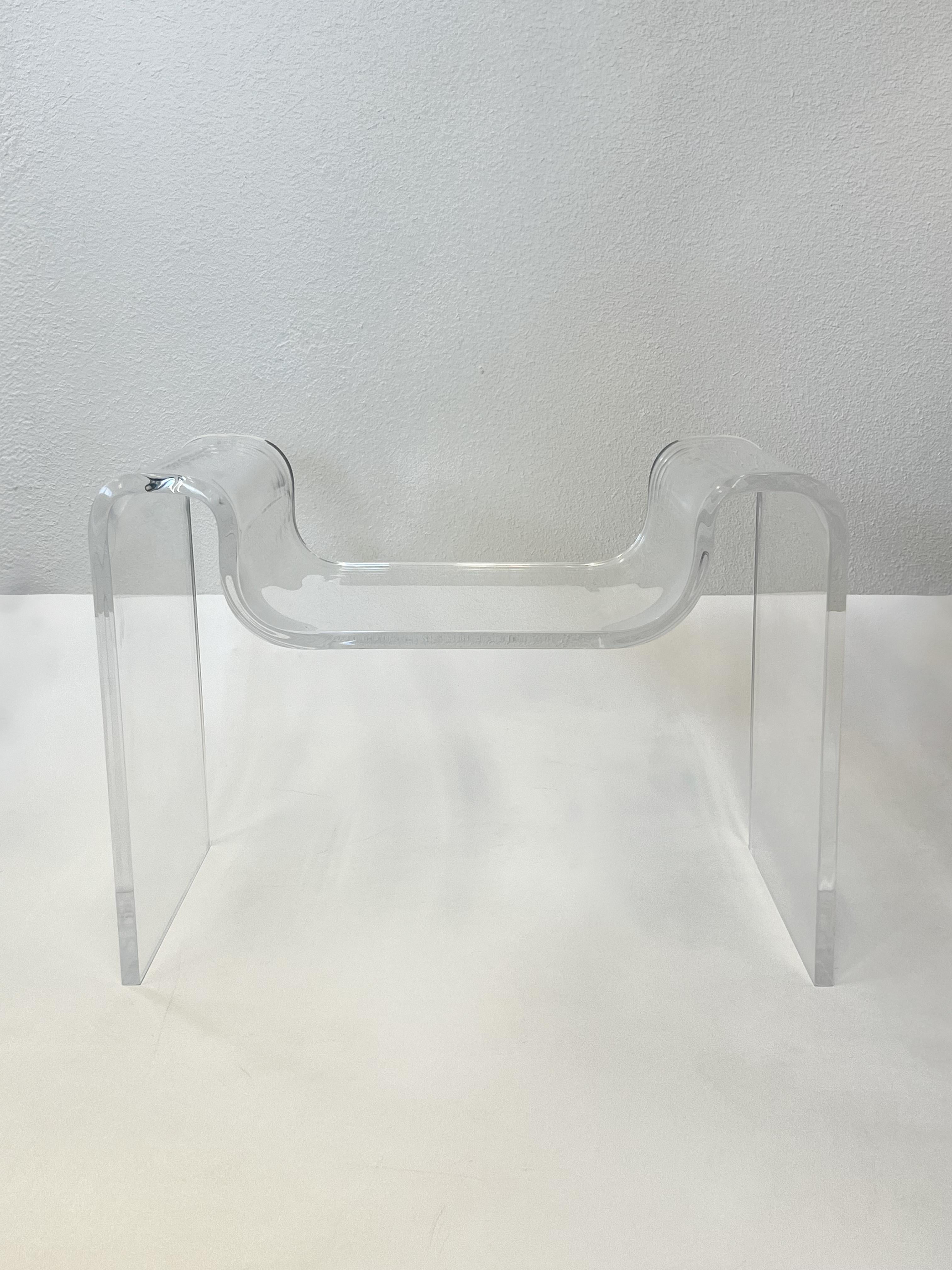 1970’s Sculptural clear acrylic bench by Karl Springer.
Constructed of one piece of acrylic that’s molded in to shape. 
Newly professionally polished.
Measurements: 28” Wide, 15” Deep, 20” High, 14” Seat.