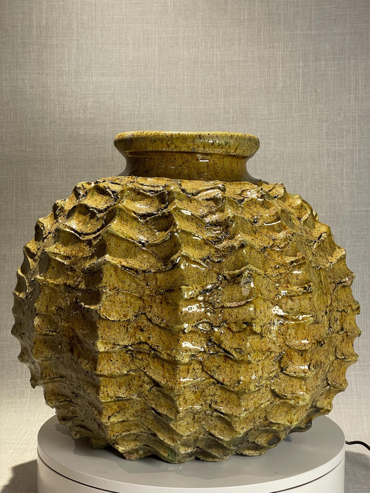 Questo vaso scultoreo realizzato a mano in Studio Pottery è un esempio audace e di grande impatto visivo dell'arte ceramica del XX secolo. Caratterizzato da un corpo fortemente strutturato, la superficie è ornata da creste e motivi che ricordano