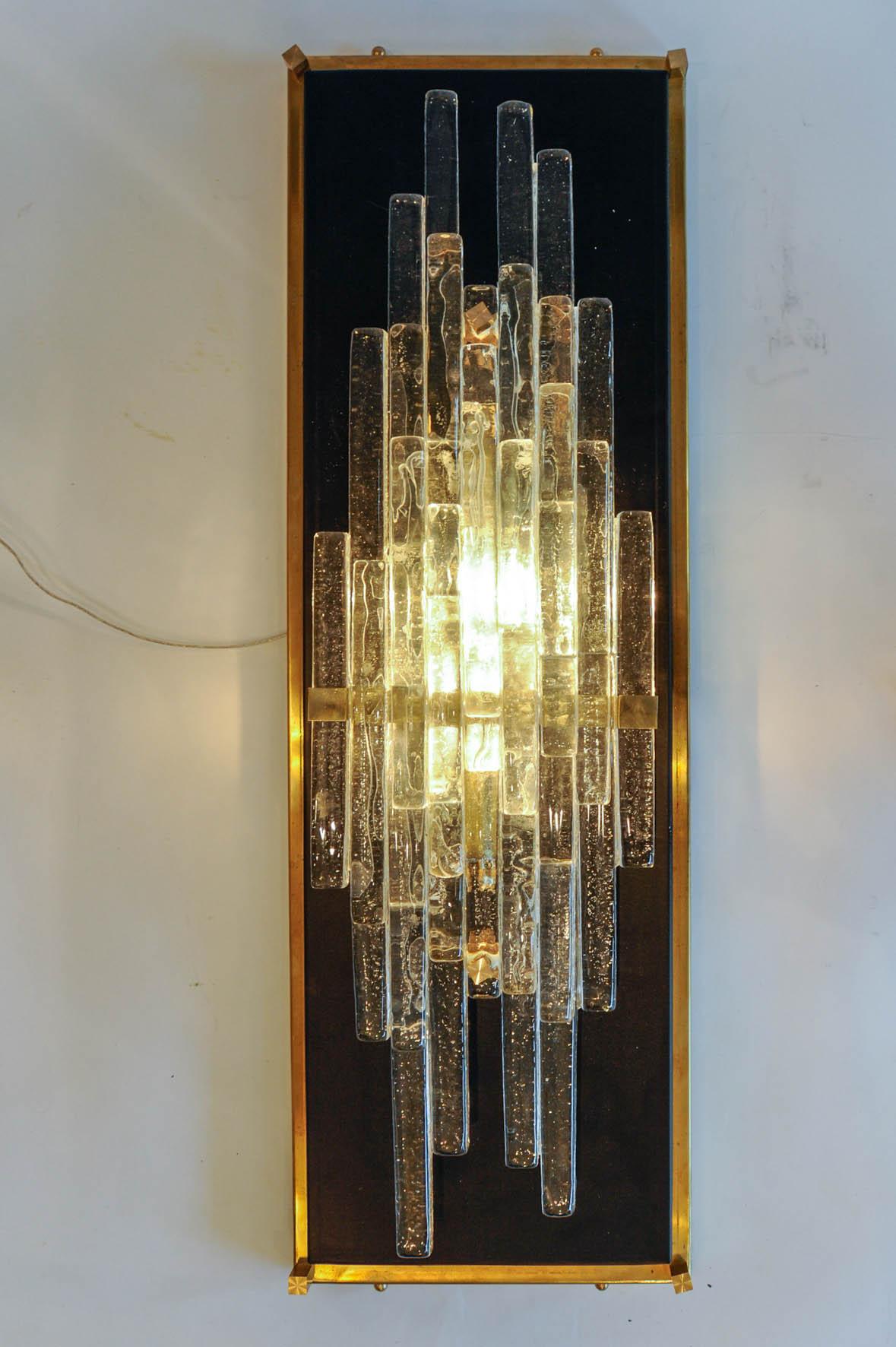 These Murano glass sconces are composed of two-light bulbs each, back on a black mirror and with a brass structure. Three pairs are available.