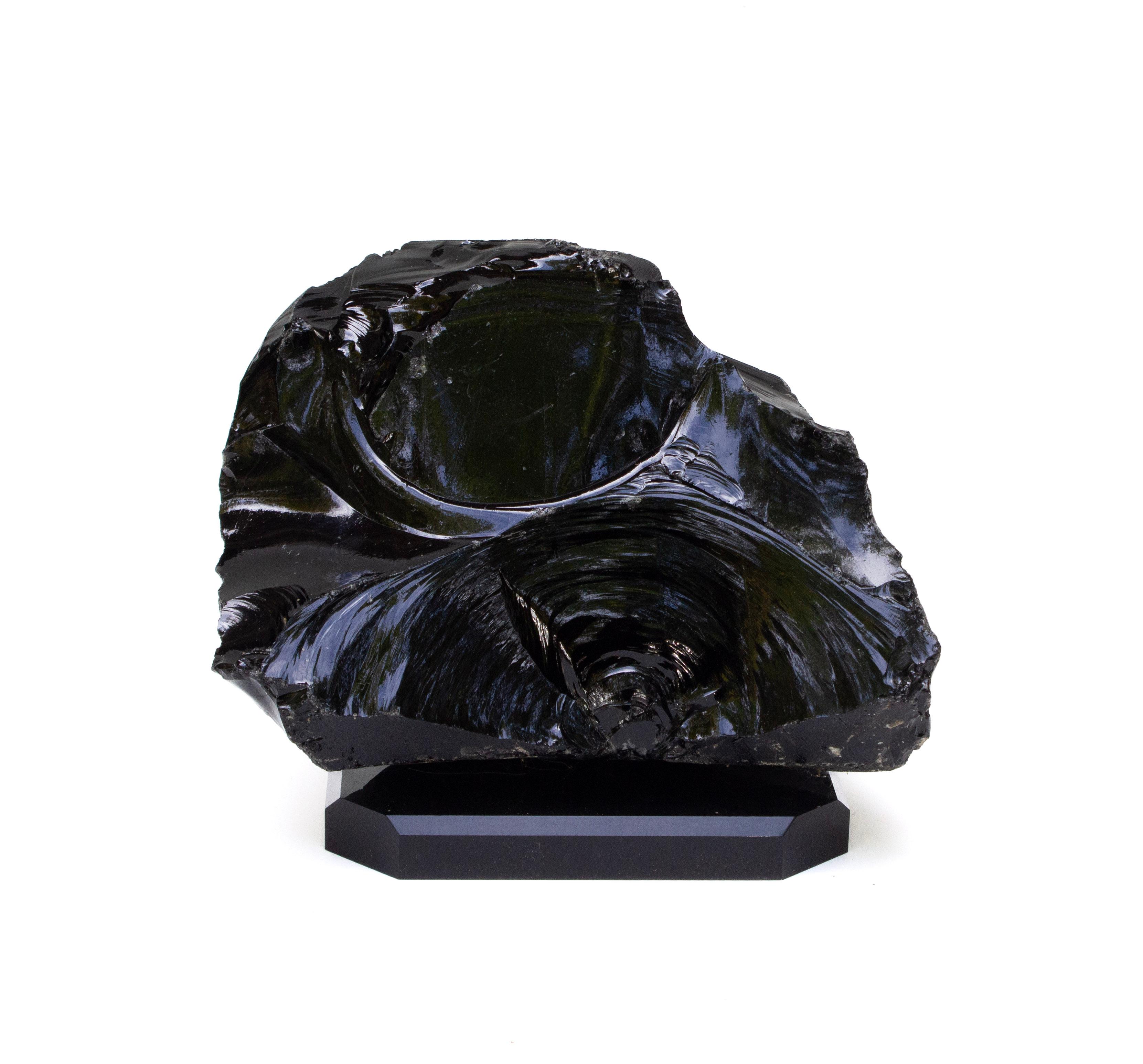 Large naturally formed black obsidian on a black base.

Obsidian is a naturally occurring volcanic glass formed when lava extruded from a volcano cools rapidly with minimal crystal growth. It is an igneous rock. Obsidian is produced from felsic
